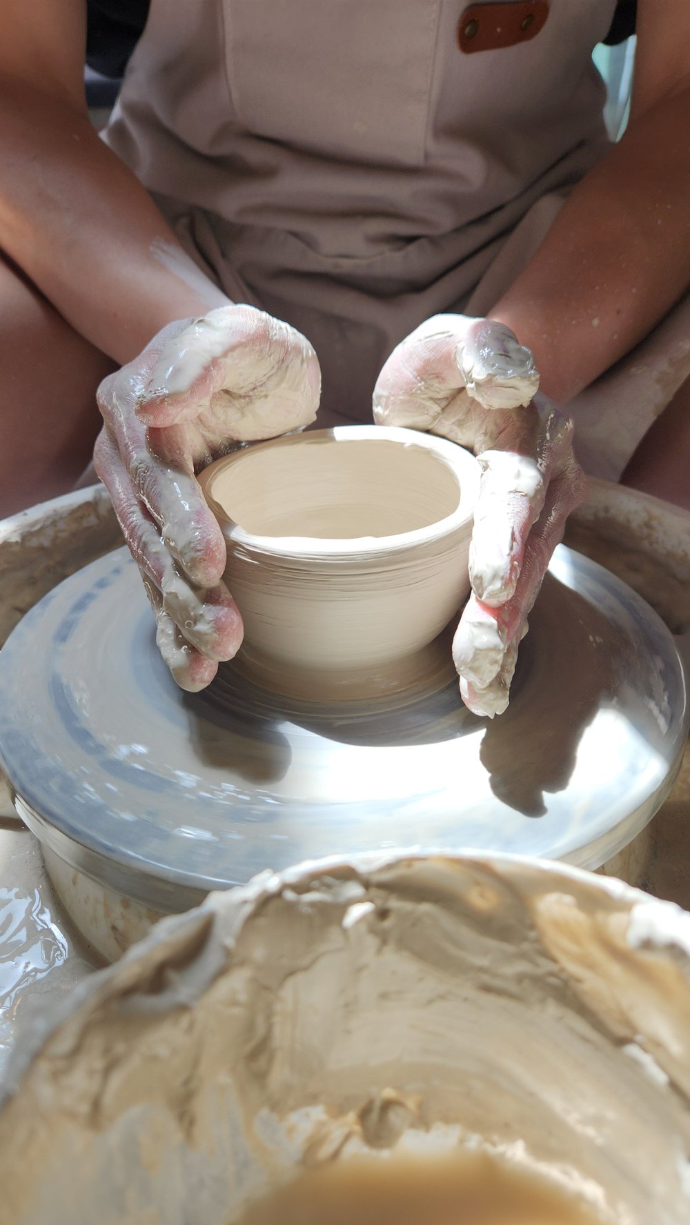 Beginner throwing on the potter's wheel in Oakland