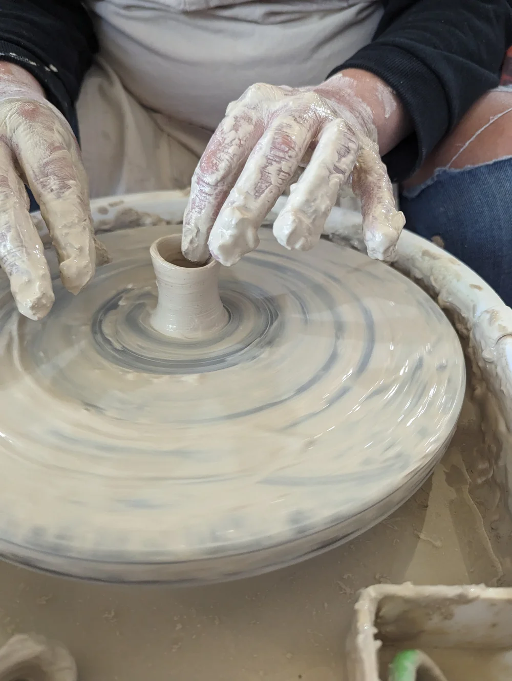 Beginner pottery class throwing on the wheel