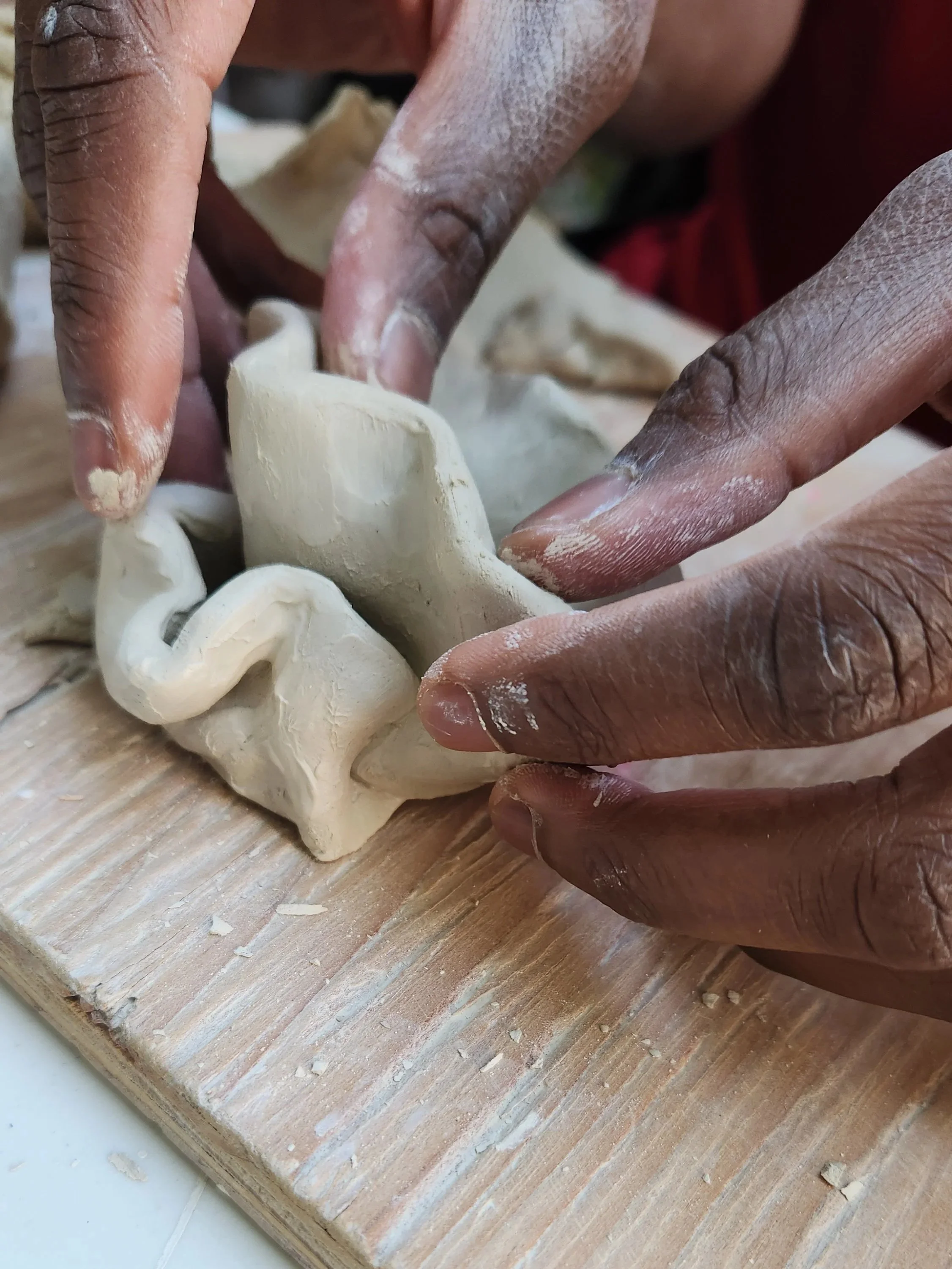 Hands shape an intricate clay piece at a cozy pottery studio in Oakland