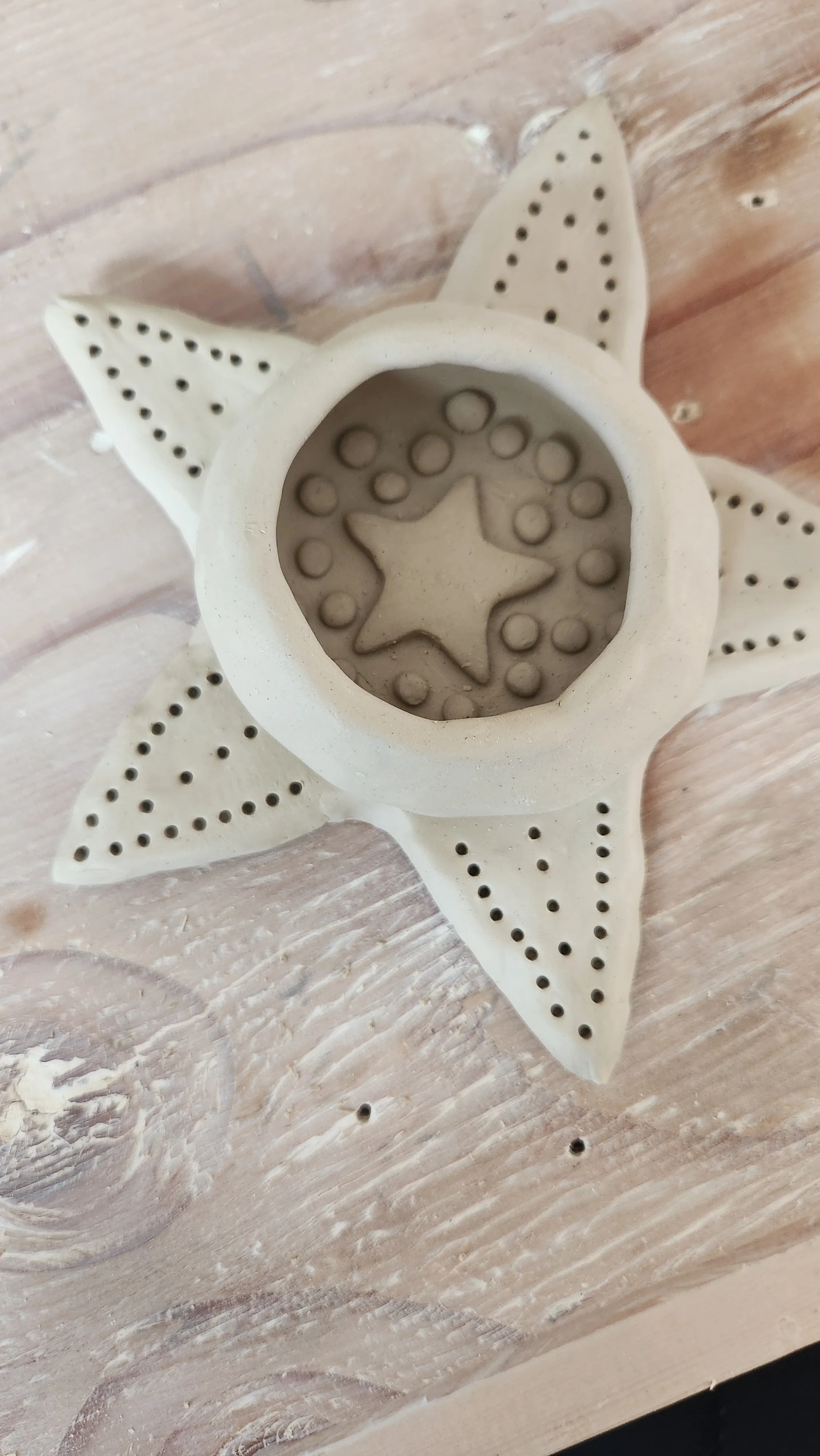 An overhead photo of a handcrafted clay piece on a wooden table