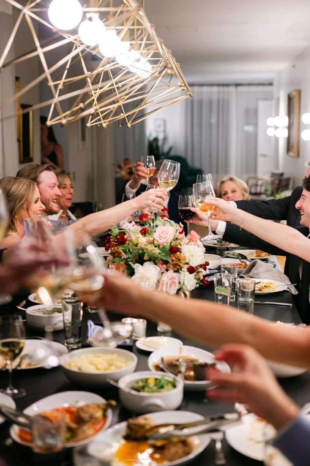 guests-clink-glasses-across-table-at-small-intimate-dinner-in-the-monument-suite-of-the-line-hotel.jpg.jpg
