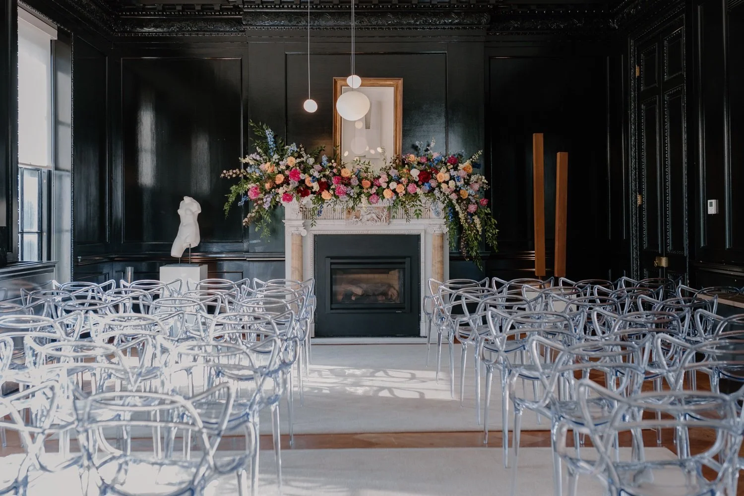 clear-acrylic-ceremony-chairs-and-rainbow-colored-wedding-flowers-on-mantle-at-patterson-mansion-.jpg.jpg