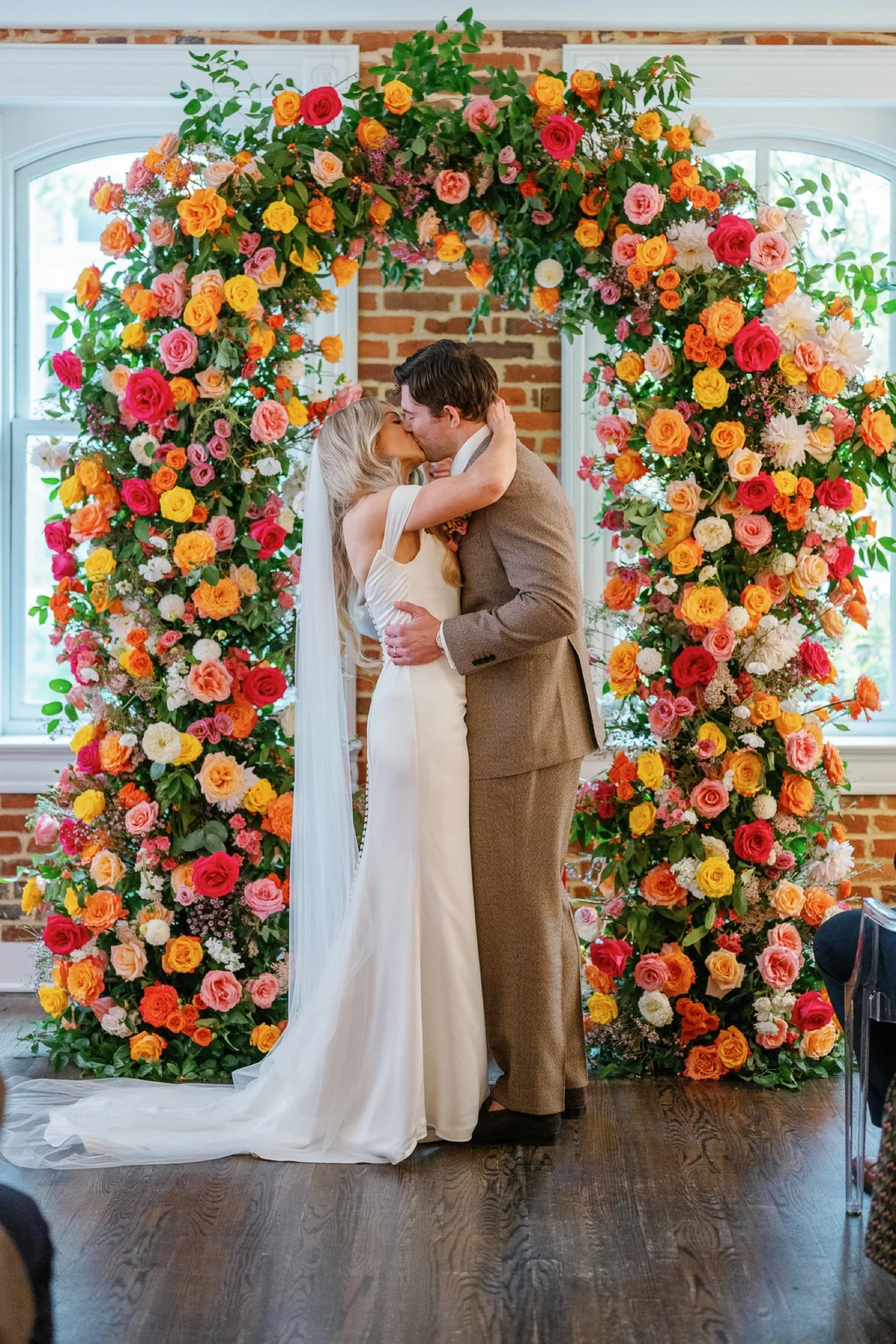 bride-and-groom-kiss-under-floral-arch-at-fathom-gallery-micro-wedding.jpg.jpg