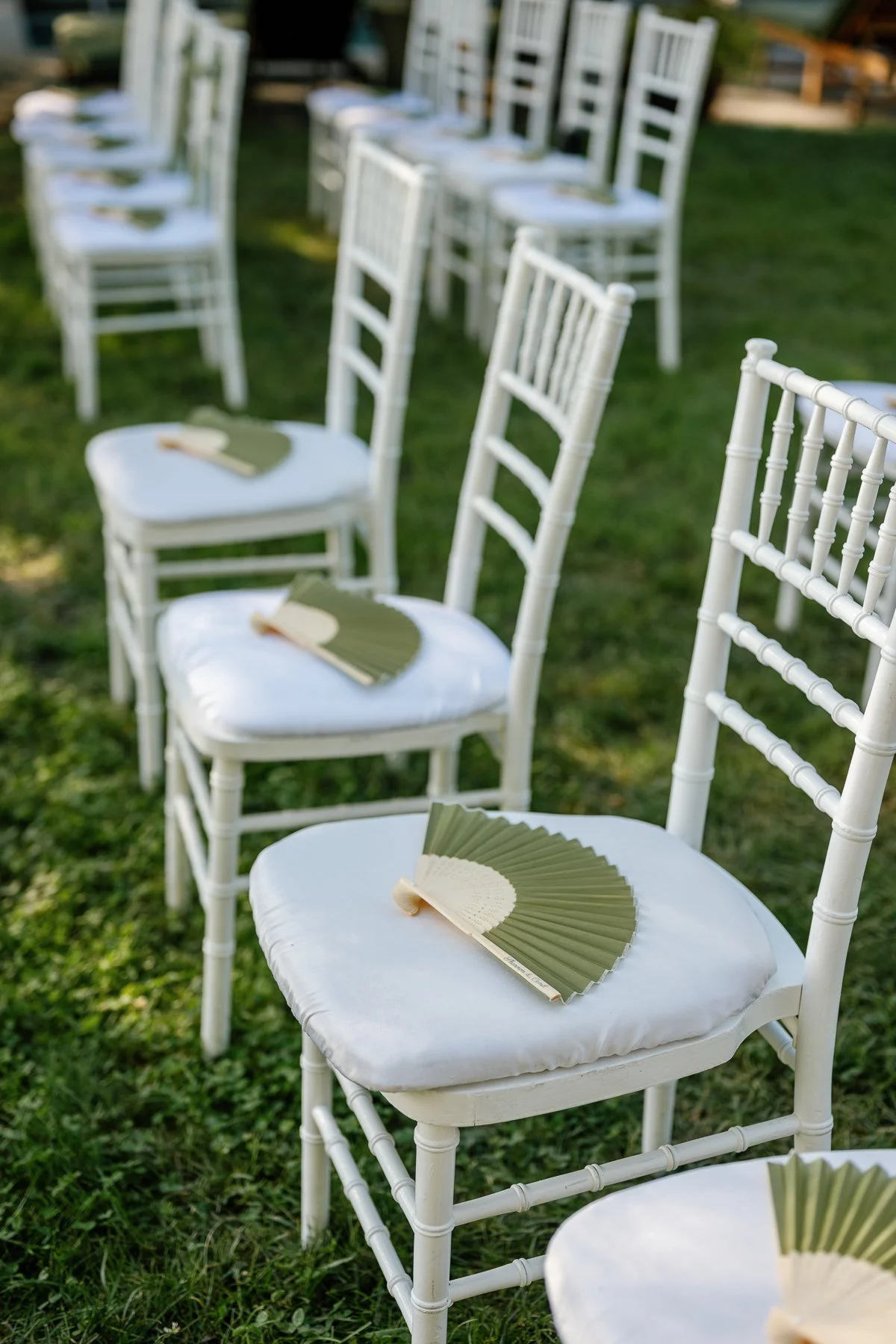  Sage-green engraved fans on white chairs for a Goodstone Inn micro wedding ceremony 