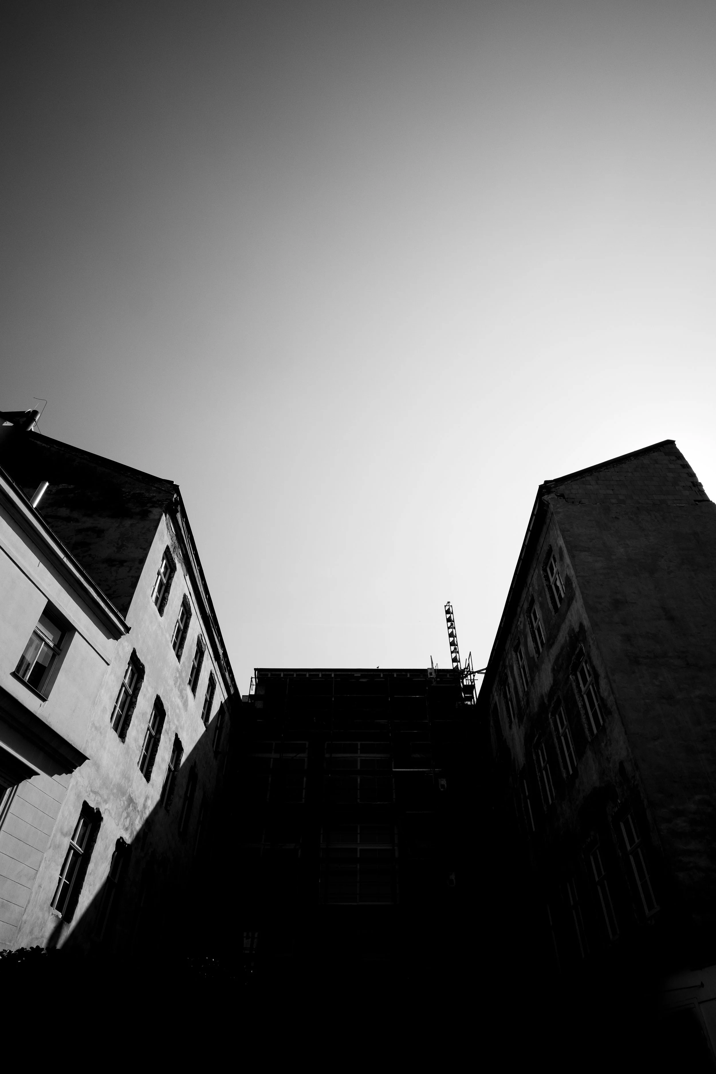 Black and white photo of tall buildings with a clear sky above.