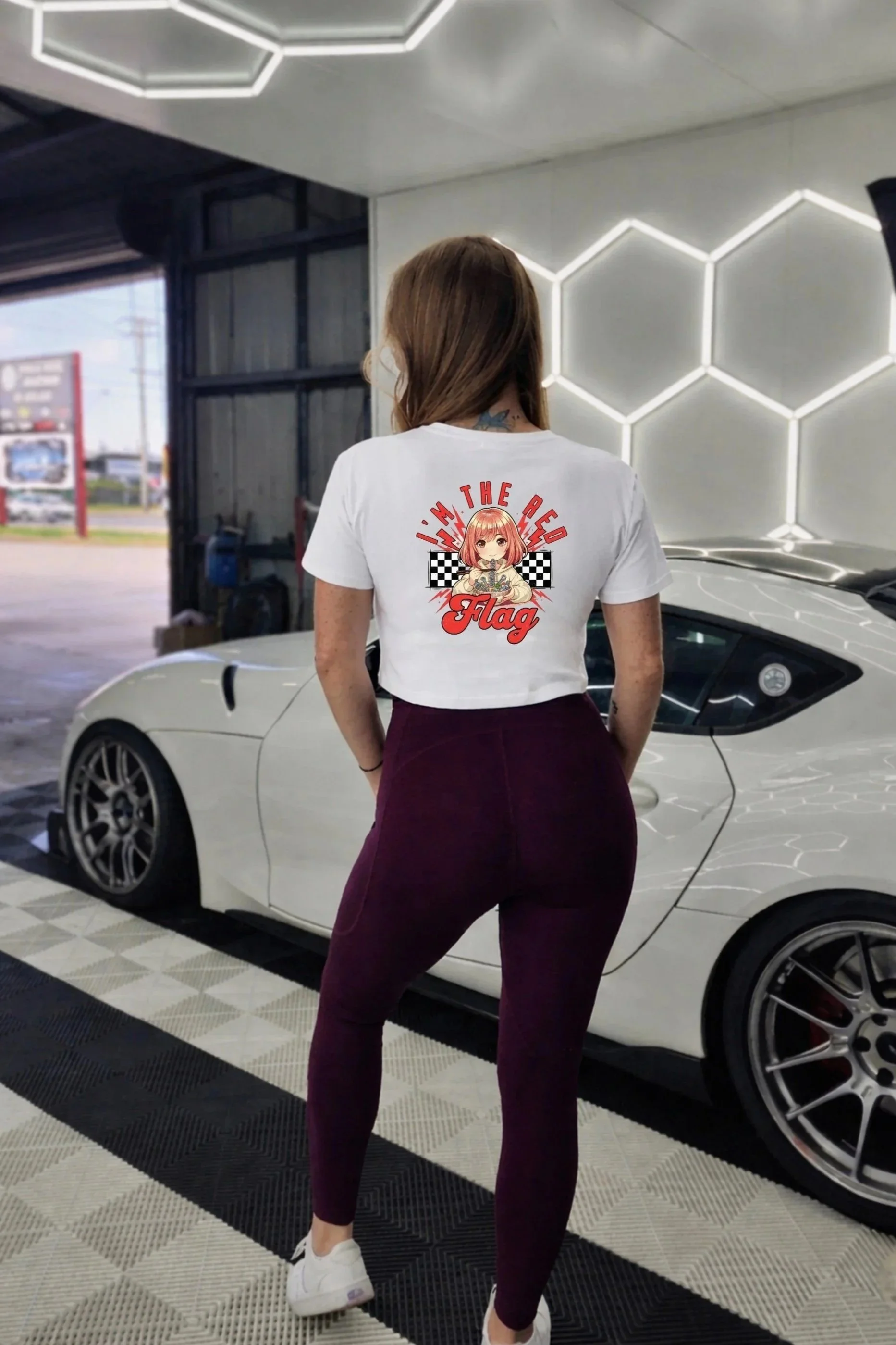 Graphic baby tee and streetwear crop top for women in the car scene.