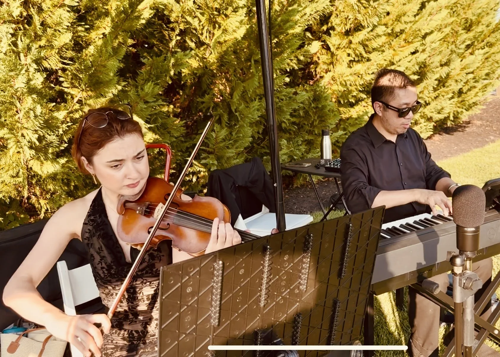 Violinist Irina Rostomashvilli and pianist Sanford Guerrero playing outdoors at Renault Winery in Egg Harbor Township, New Jersey.