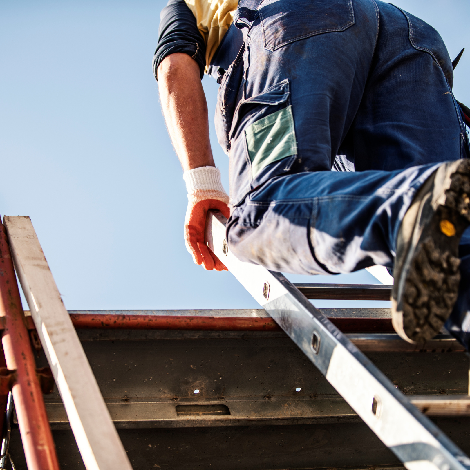 DMV Roofer climbing ladder to inspect storm-damaged roof.