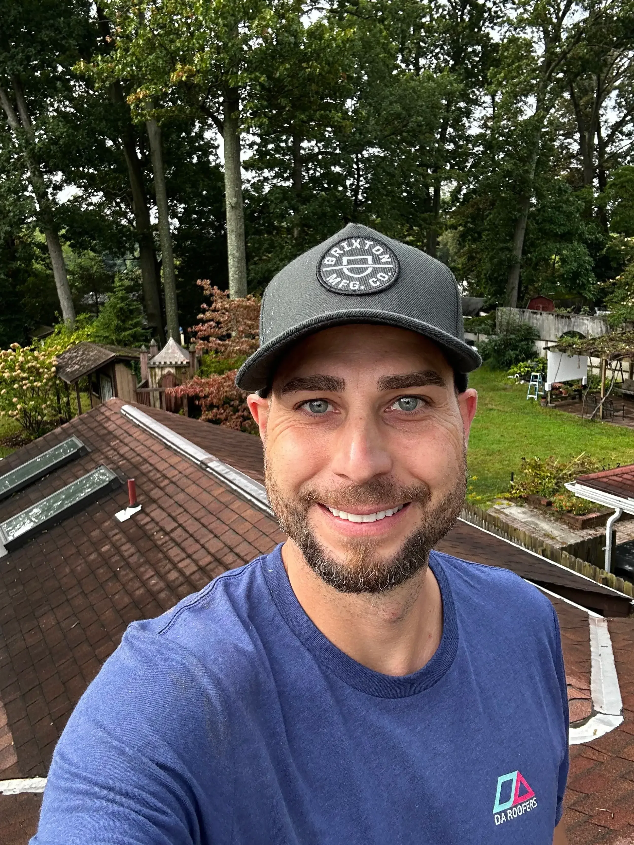 Denny smiling while on top of a roof