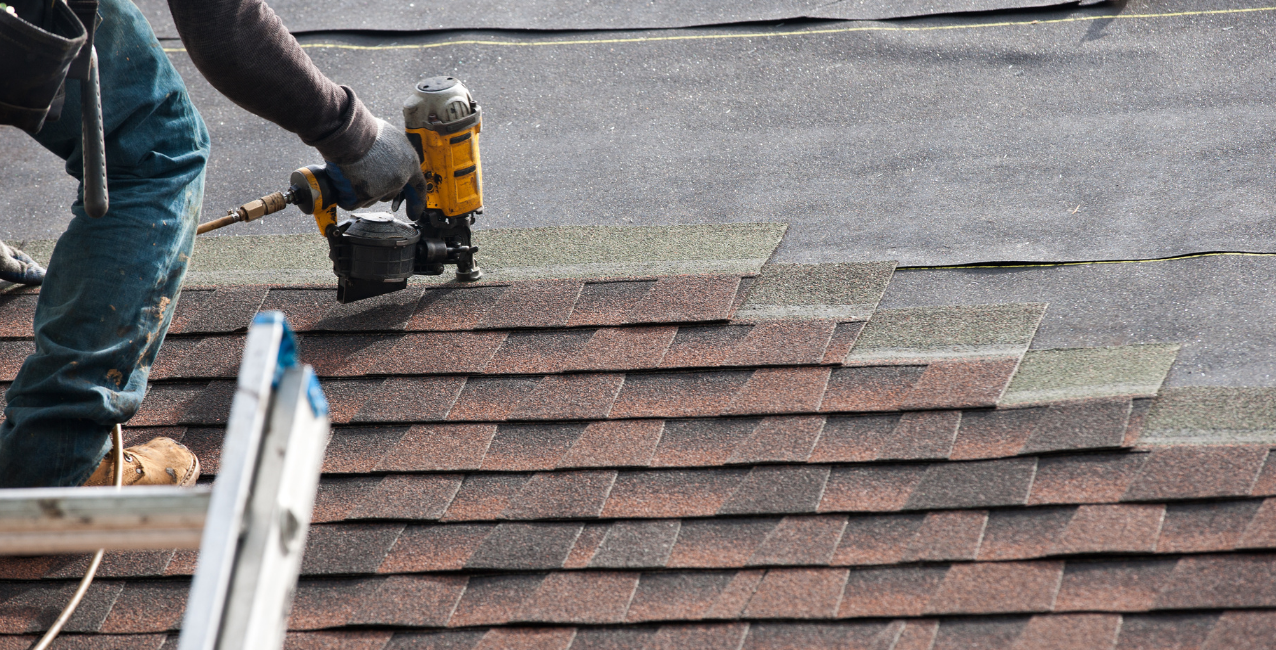 Roofing contractor carefully aligning asphalt shingles for a durable and weather-resistant roof installation.