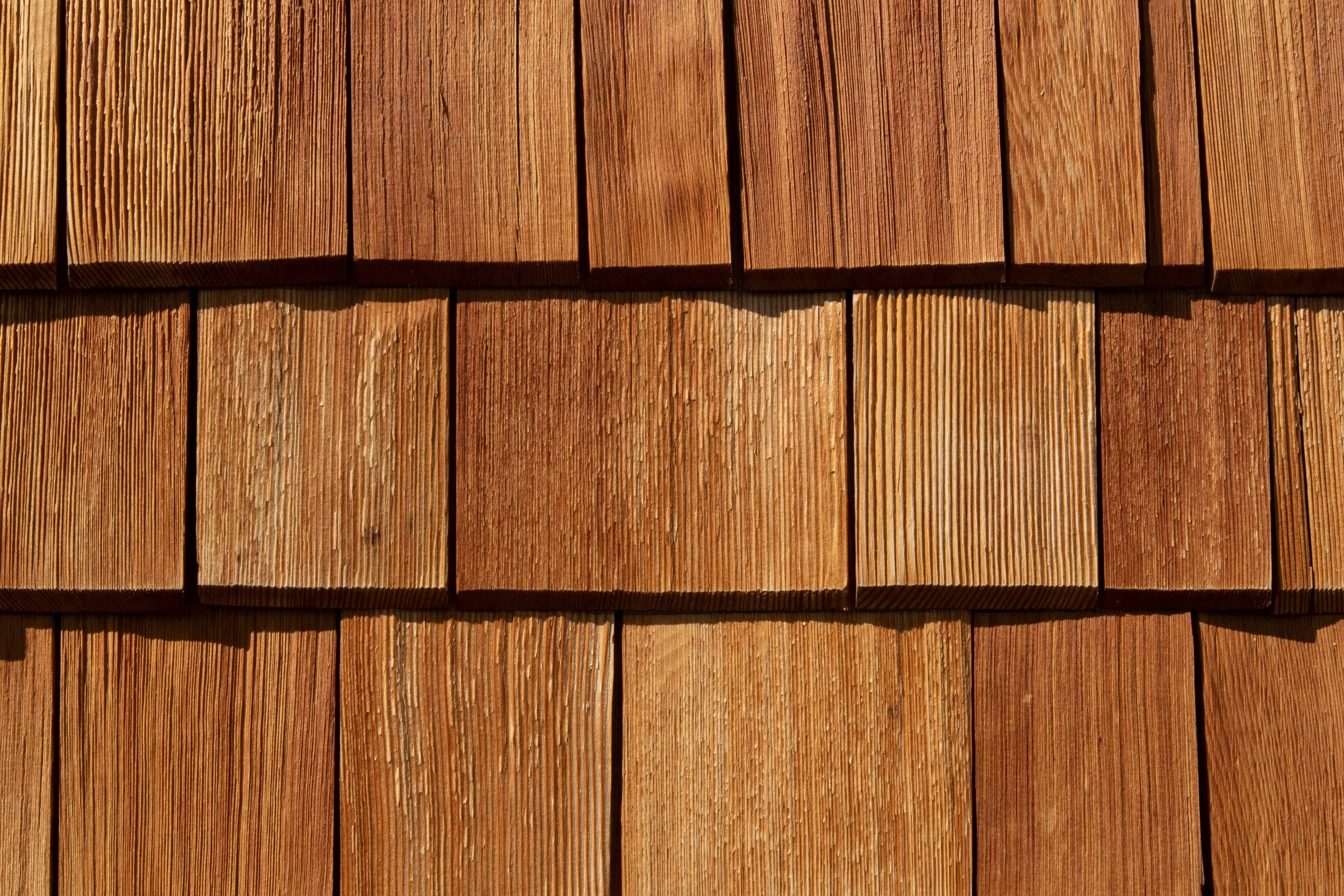 Close-up of natural cedar shake shingles showing warm wood grain and texture