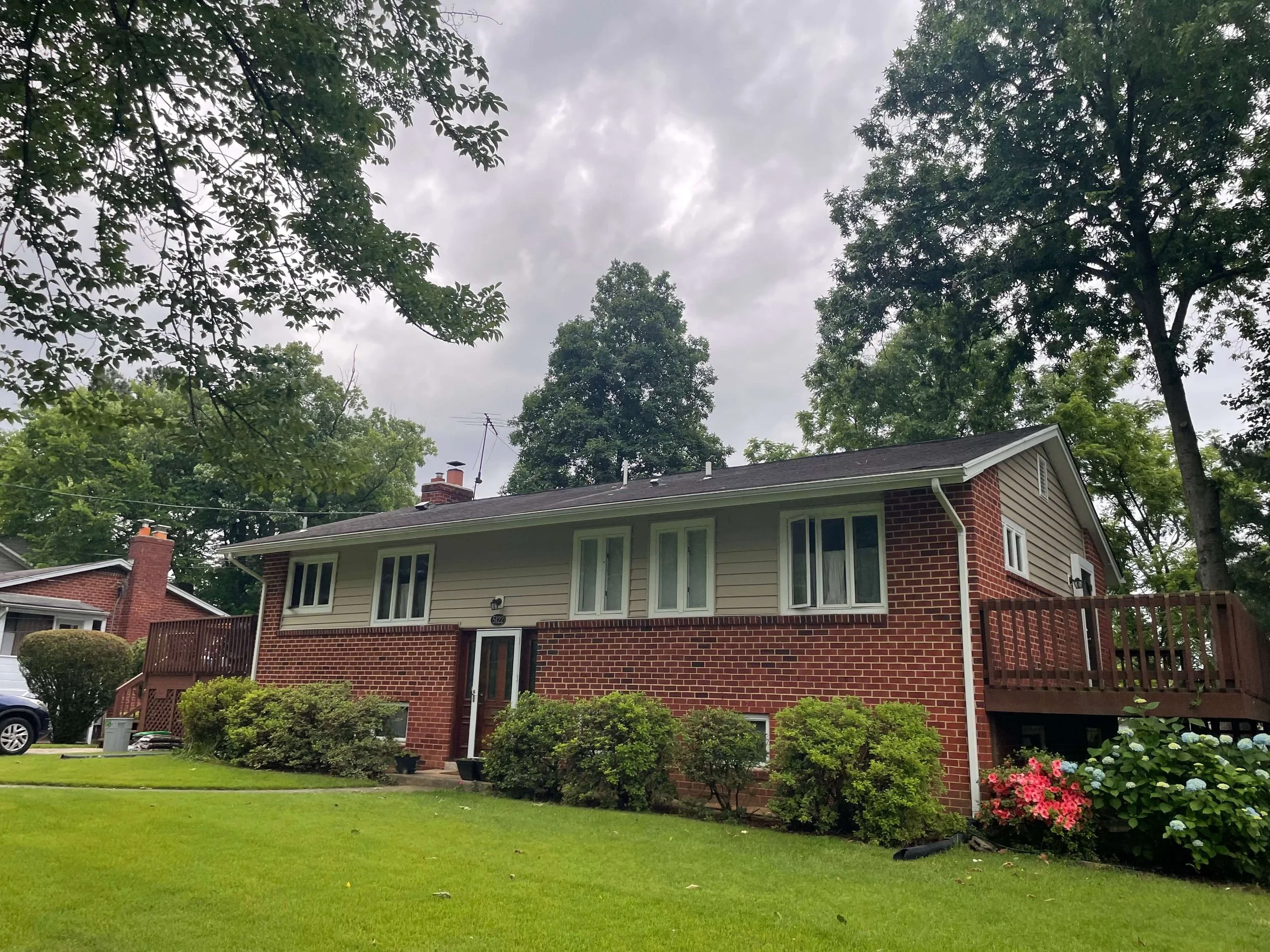 Brick split-level house with white gutters along the roofline and a white downspout at the corner