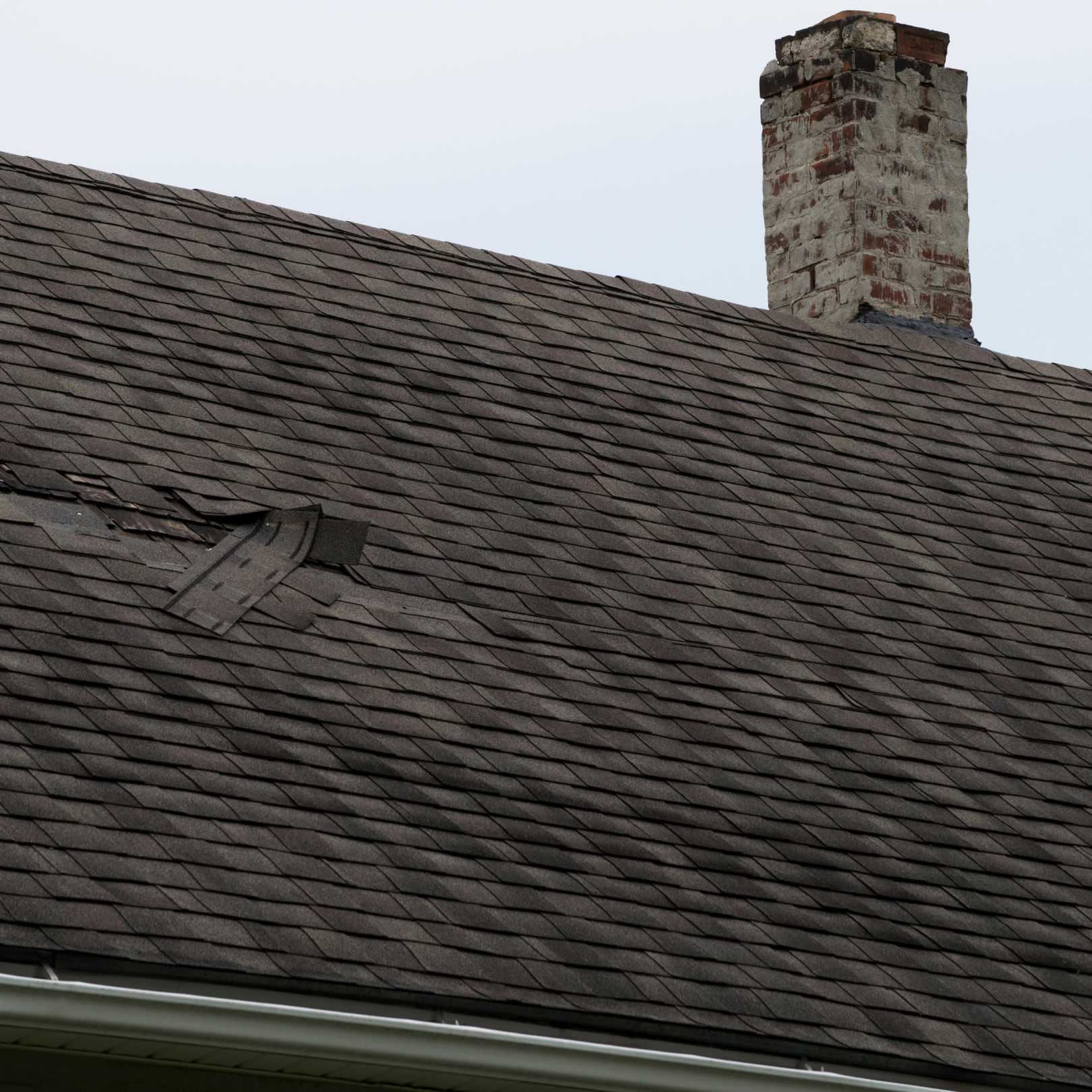 Broken shingles and leaks on a residential roof in DMV due to cheap roofing work.