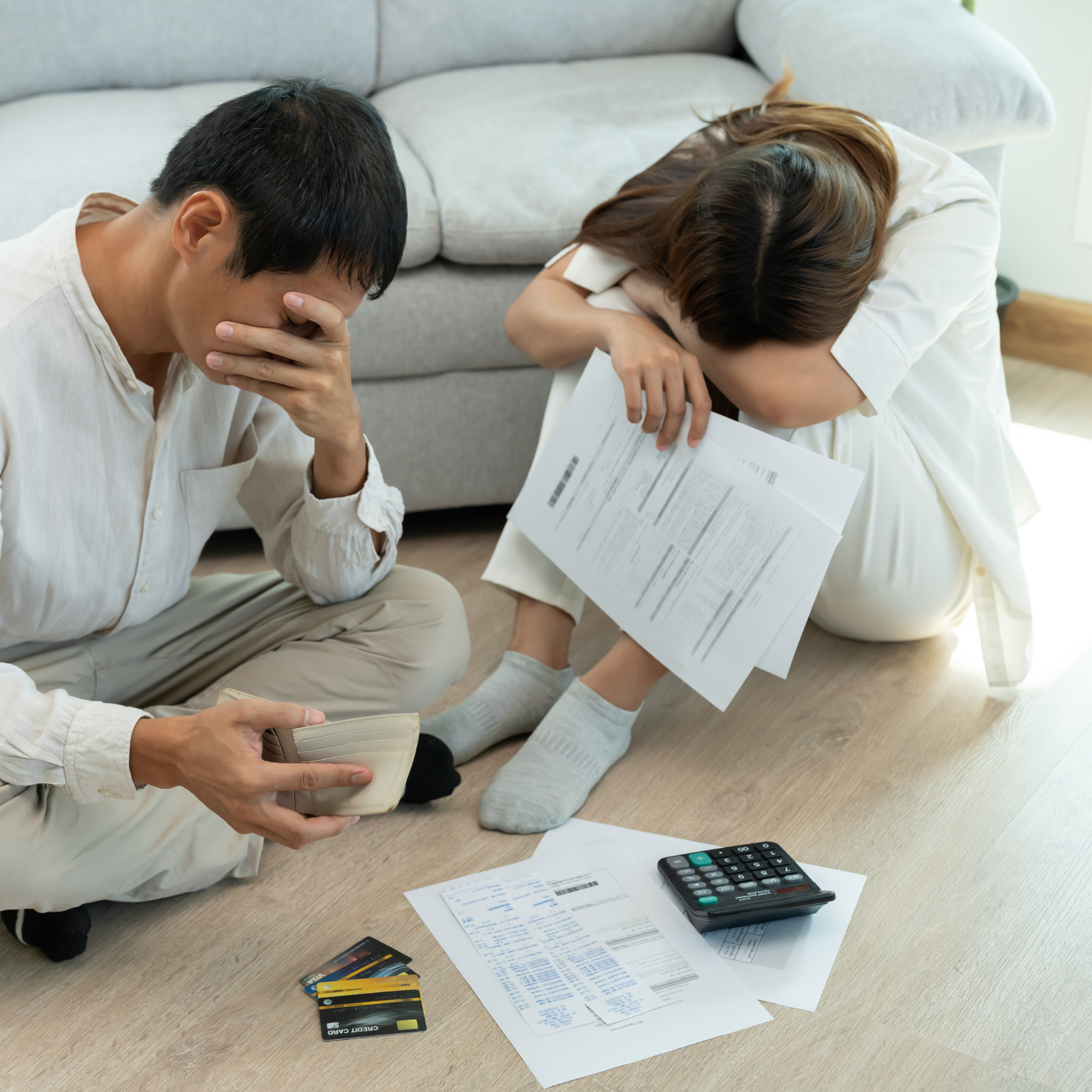 Stressed couple reviewing bills after unexpected roof repair costs from low-quality roofing