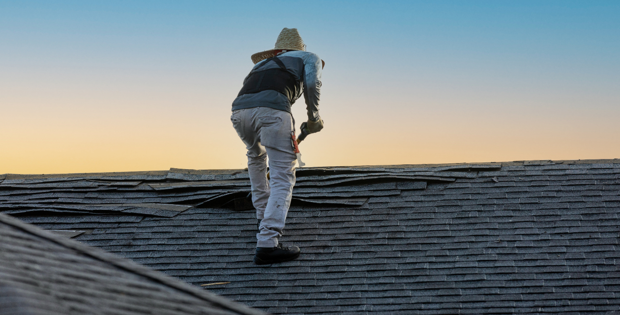 Professional roofing contractor stripping shingles from a residential roof