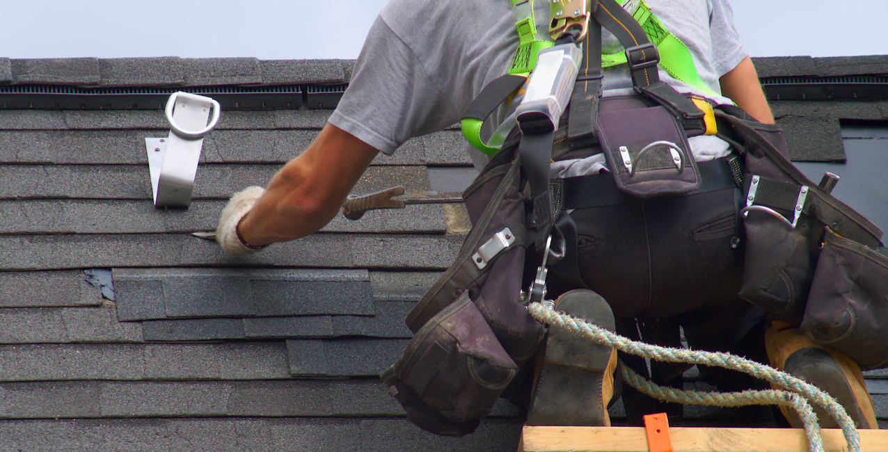 Licensed roofing contractor repairing shingle damage in DMV