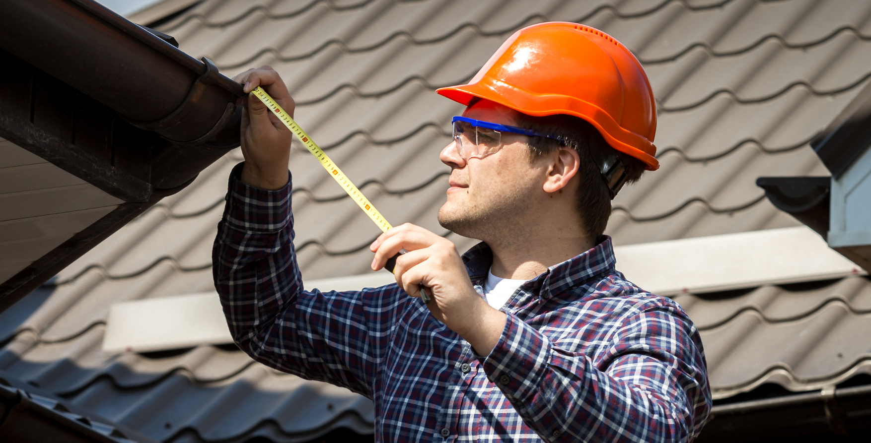 Roofer measuring a roof before giving a quote.