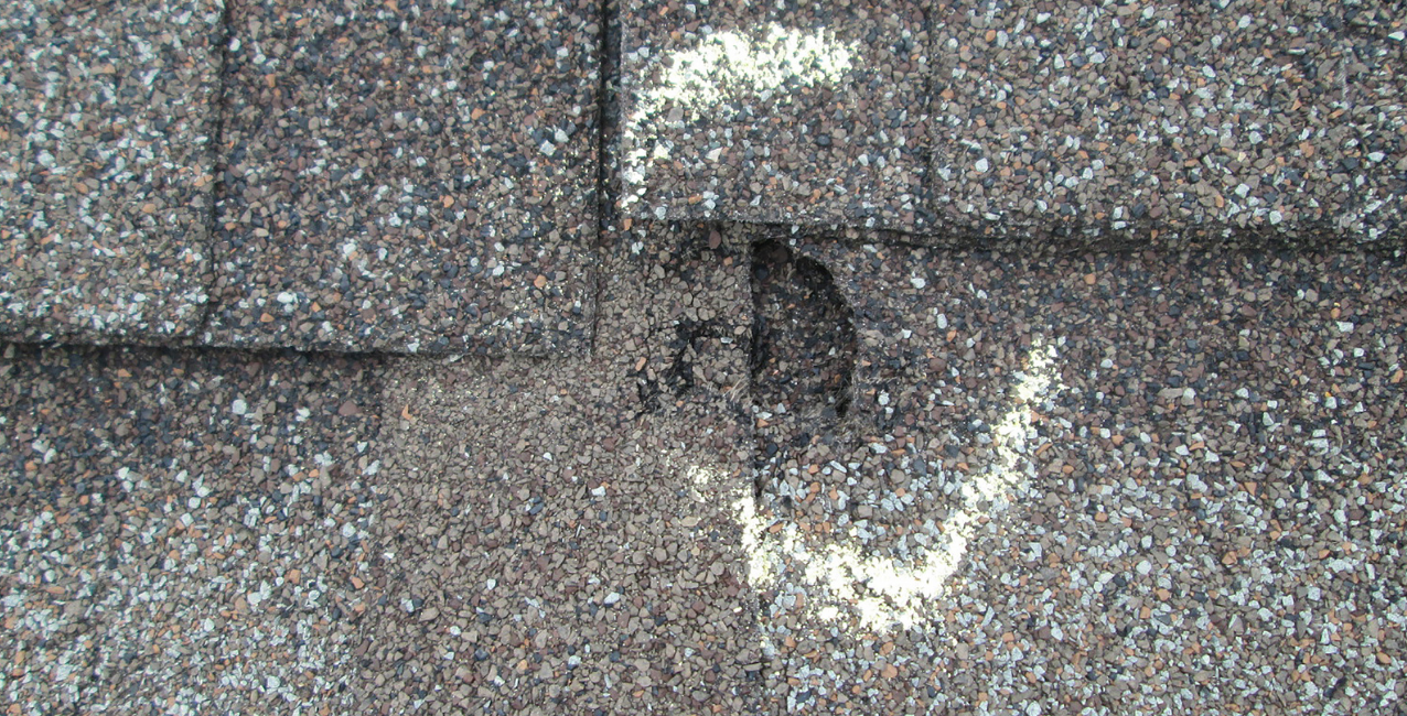 Roof showing hail damage after a storm, needing repair