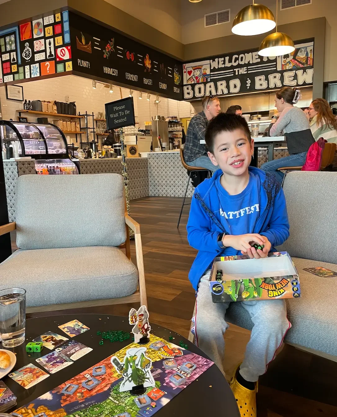A kid smiling while dining at the board and brew