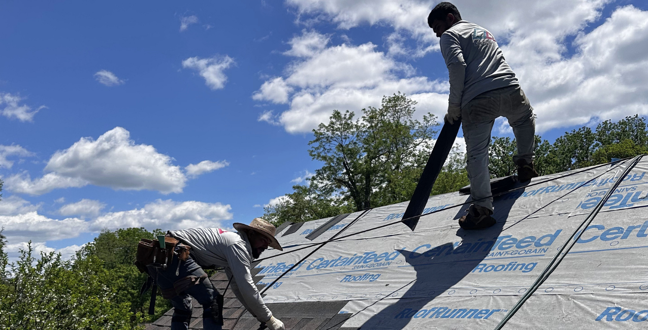 DMV Roofing contractor laying out starter shingles along the roof edge before installing asphalt shingles.