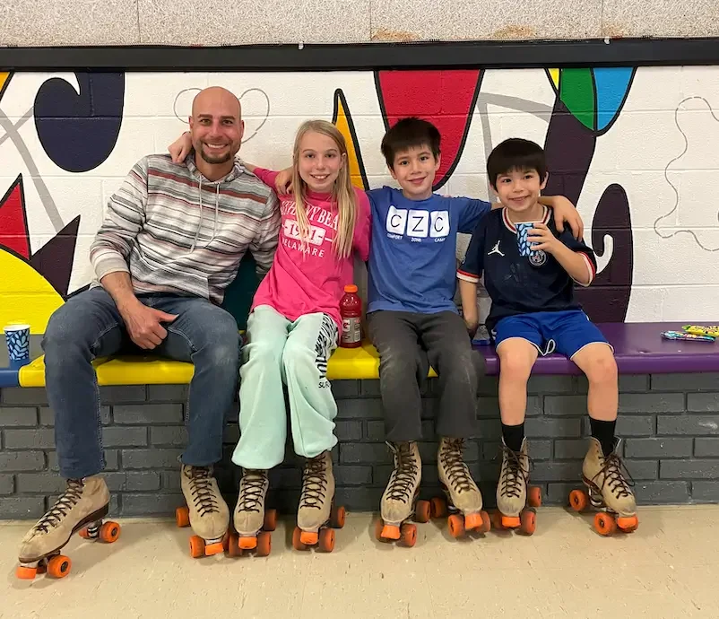 A father together with kids enjoying roller skating