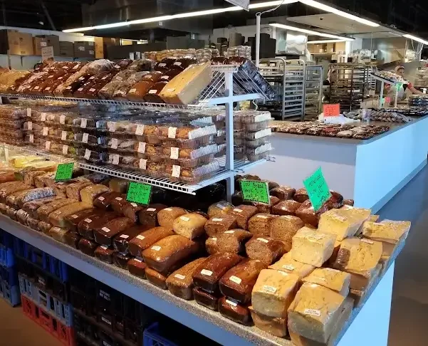 Display of various baked goods including bread and pastries in a grocery store.