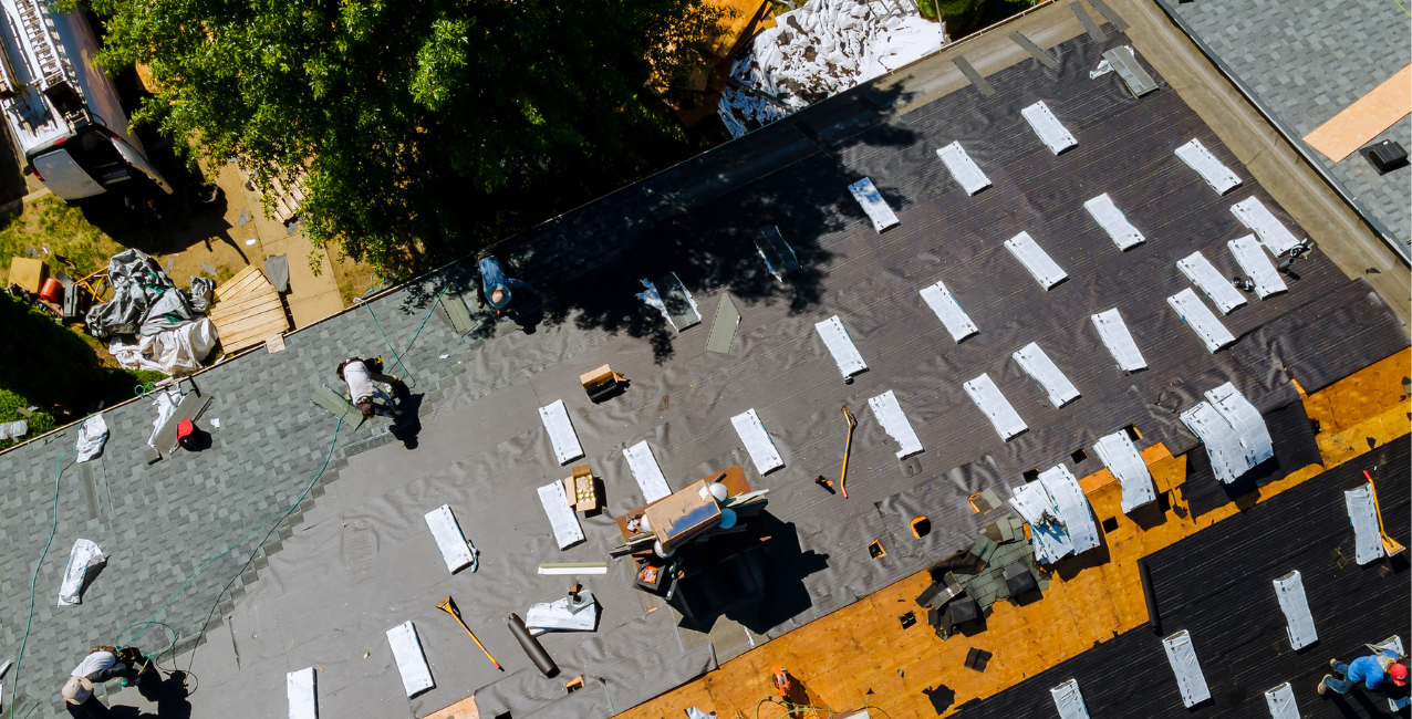 Aerial view of a residential roofing project in the DMV showing contractors installing roof underlayment.