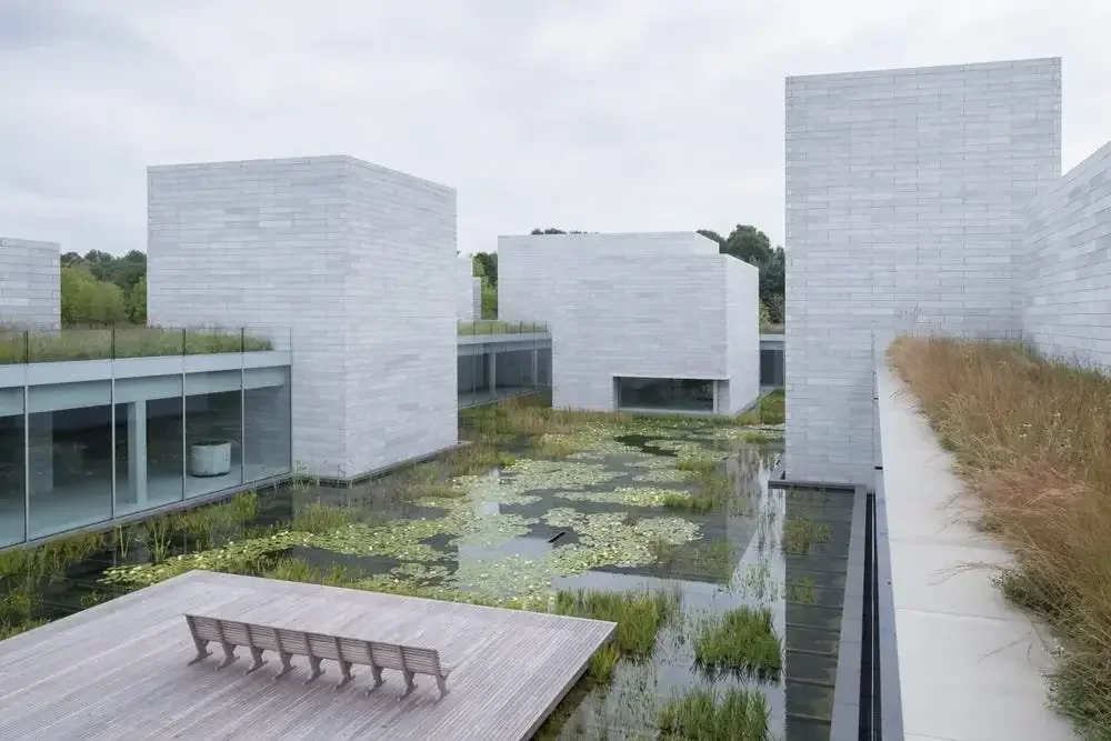 a small pond with buildings of Glenstone