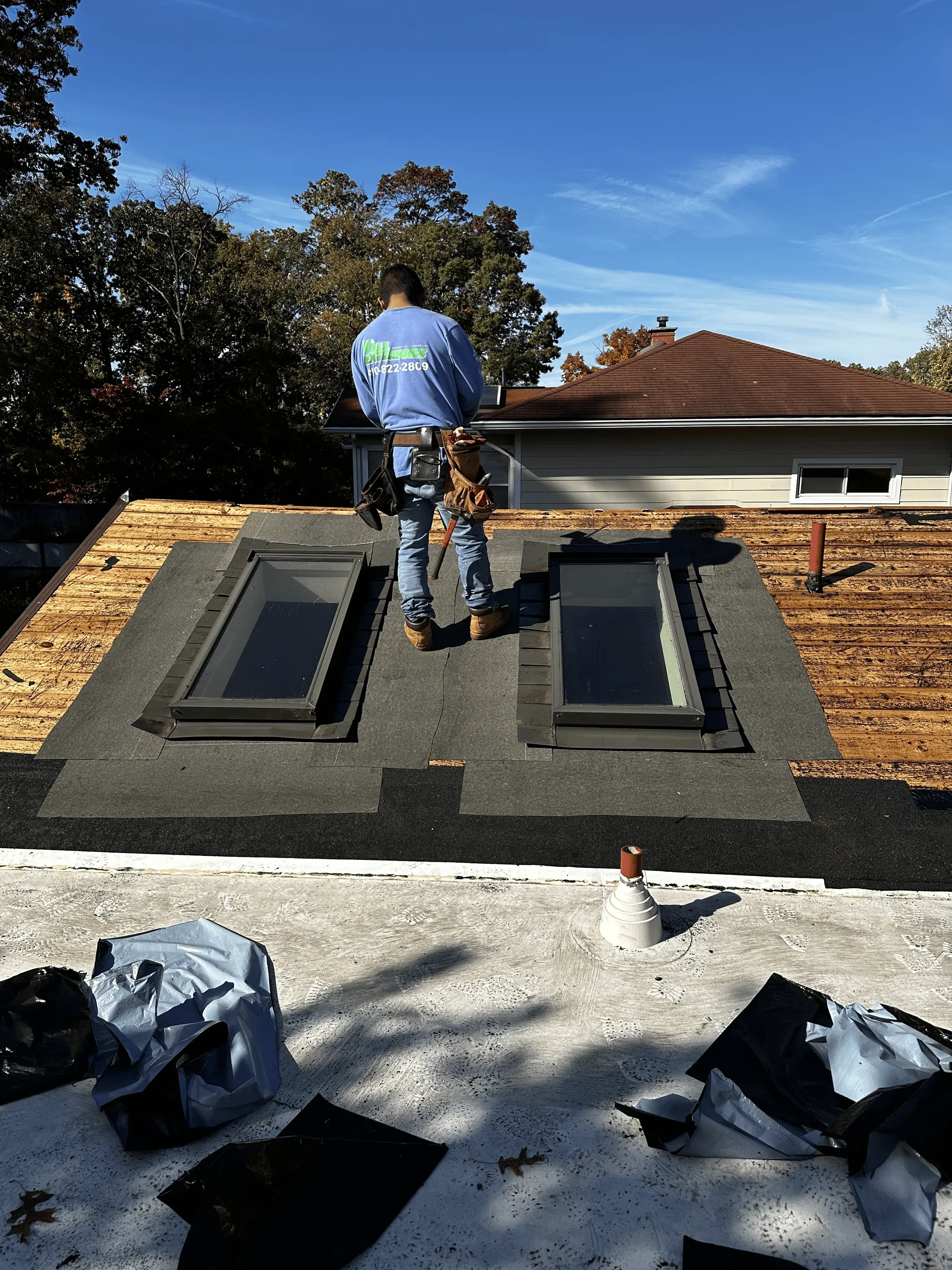 DA Roofers on the job wearing a bluer shirt and jeans