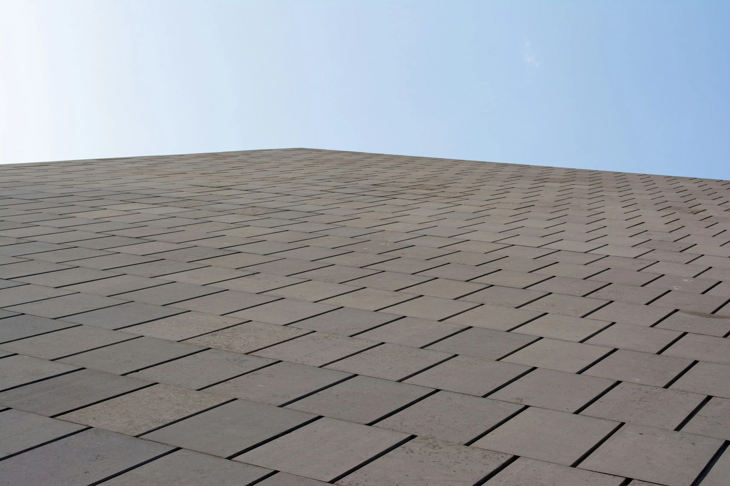 Slate-style composite shingles installed in flat, overlapping rows
