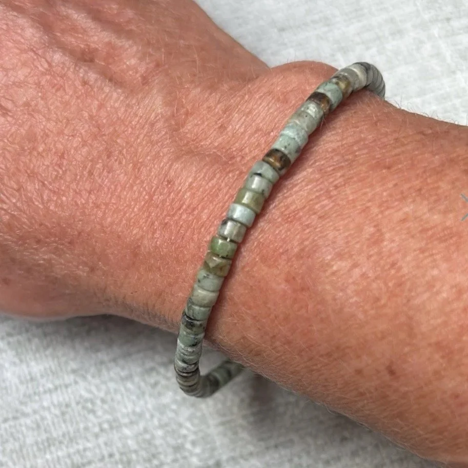 A person's arm with a beaded bracelet made of small, multicoloured African Turquoise beads.