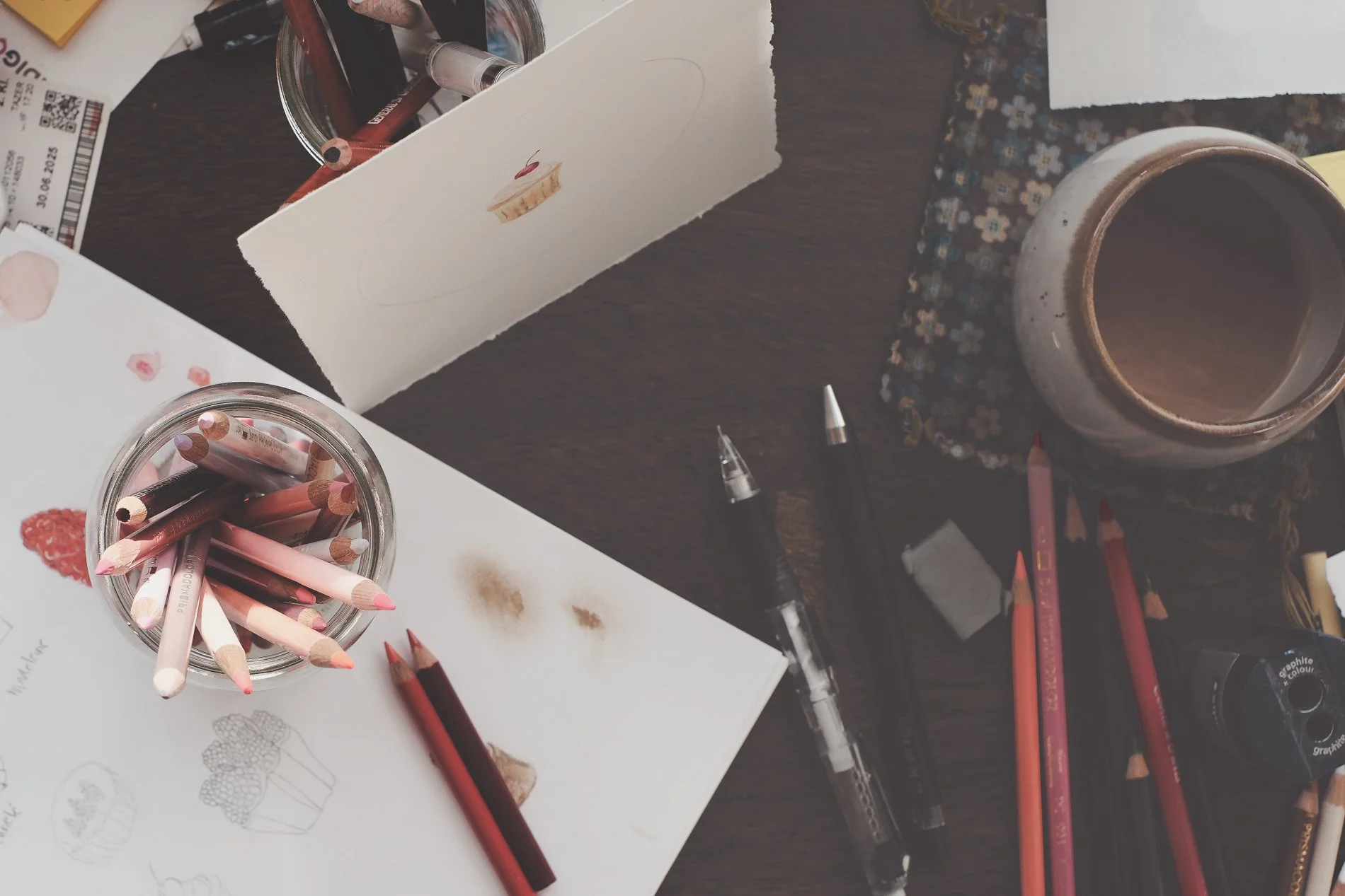 colored pencil and sketchbook and coffee on desk