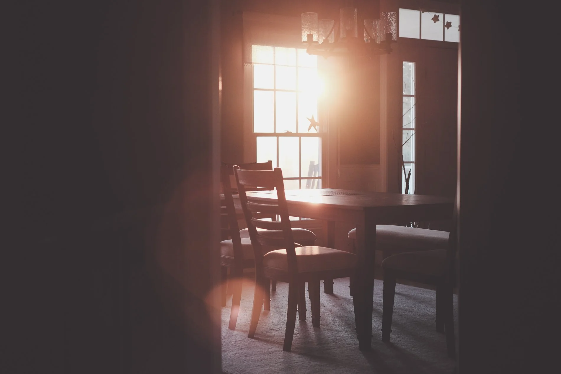 dining table and chairs with window and golden light