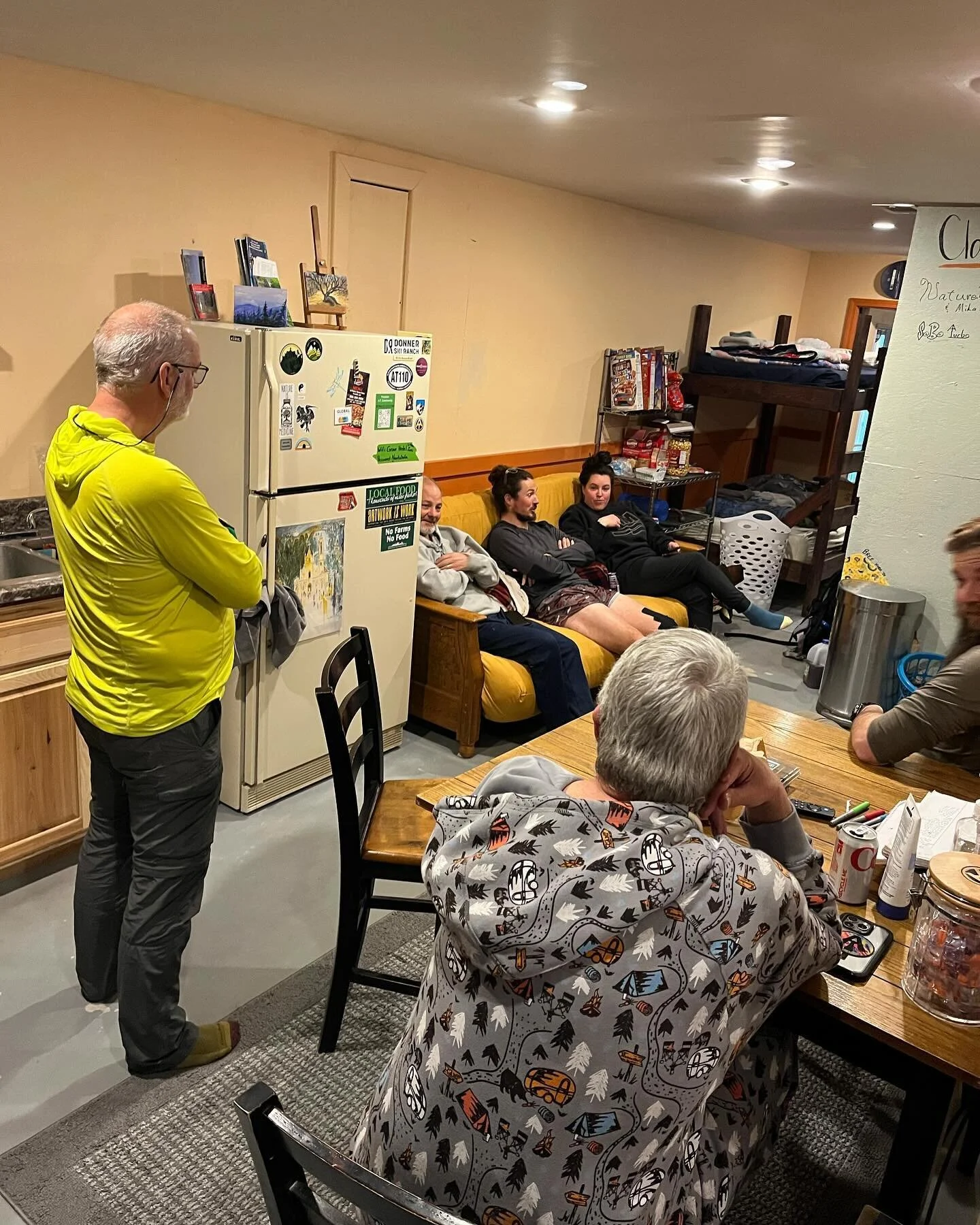 A day in the life of a hostel: zero day edition.

Hikers hanging out in the living area of the bunkroom, Boom-Boom modeling the infamous adult onesie from our loaner clothes stash, Sings With The Pines drying out some gear in the pack room, and a ver
