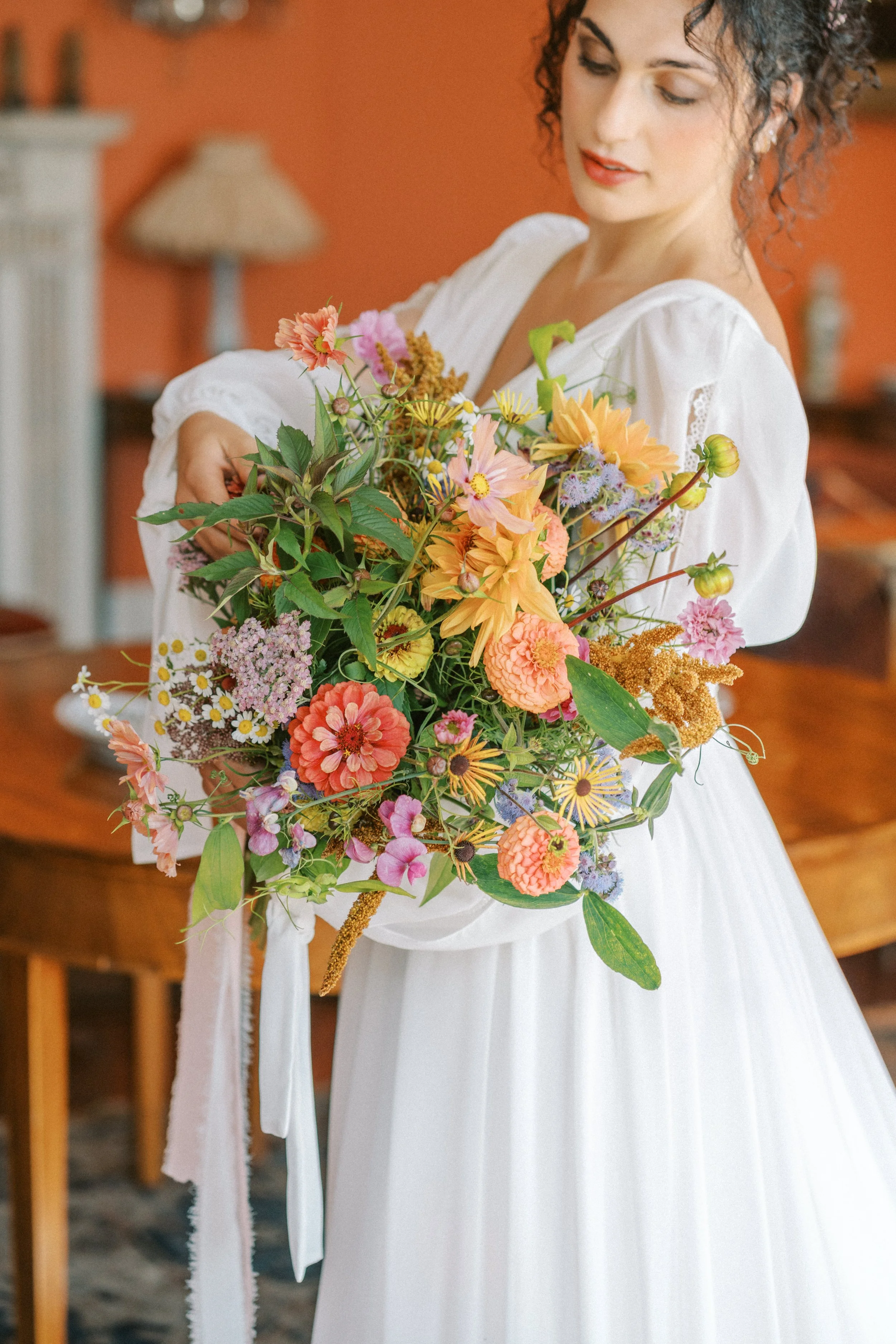 A woman in a wedding dress holding a large, colorful bouquet of flowers at an Irish summer wedding in Limerick