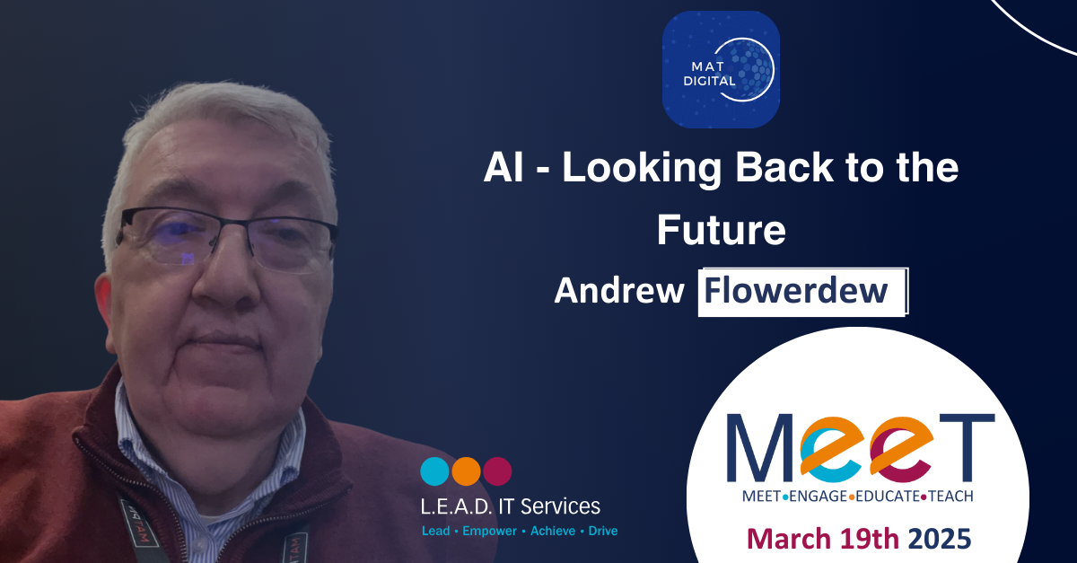 A man wearing glasses and a maroon jacket at a conference, with a presentation slide titled 'AI - Looking Back to the Future' with the name 'Andrew Flowerdew' and the date 'March 19th 2025'.