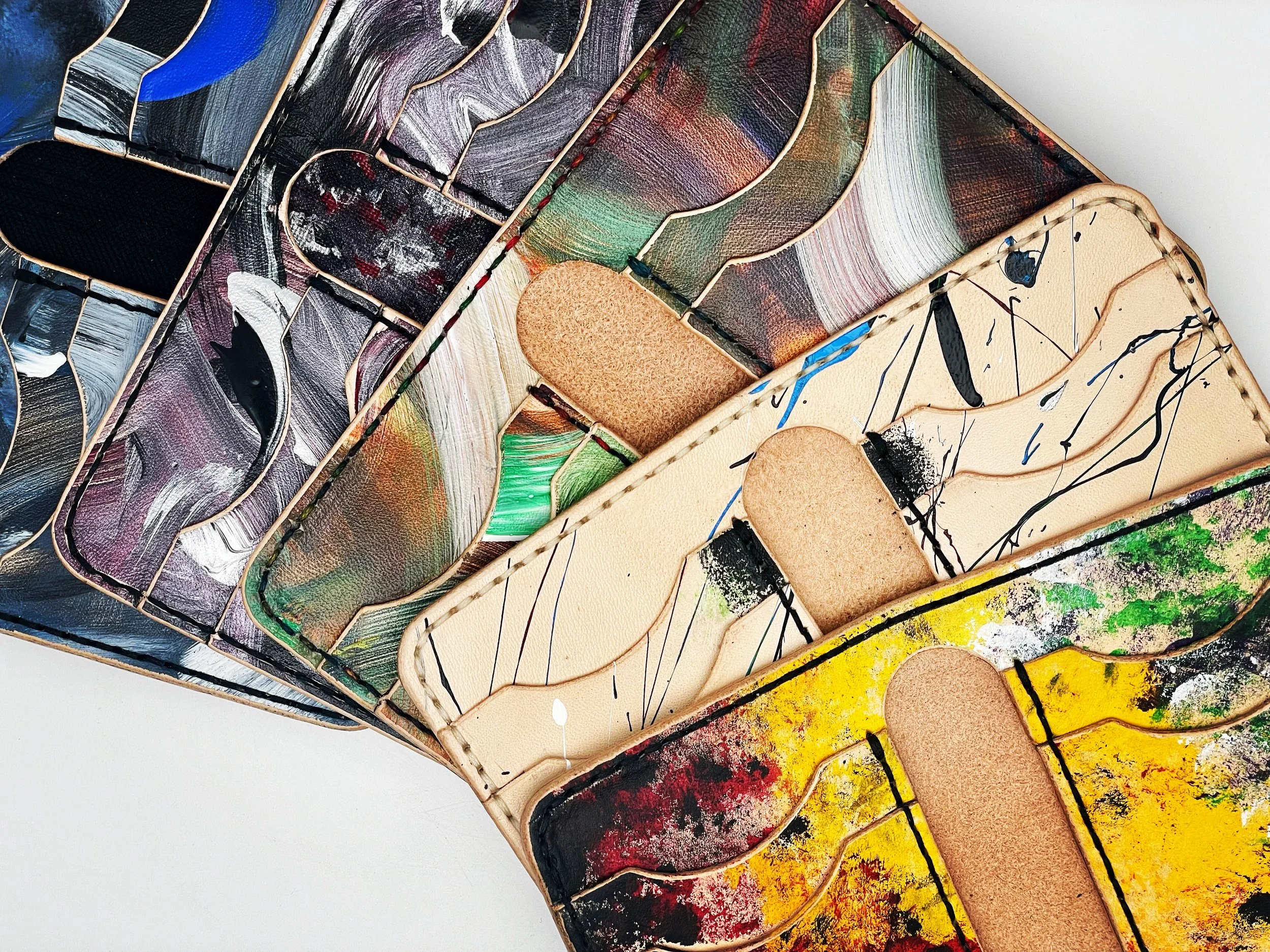 Colorful abstract painted trays arranged in a diagonal pattern, with varied artistic designs and textures.