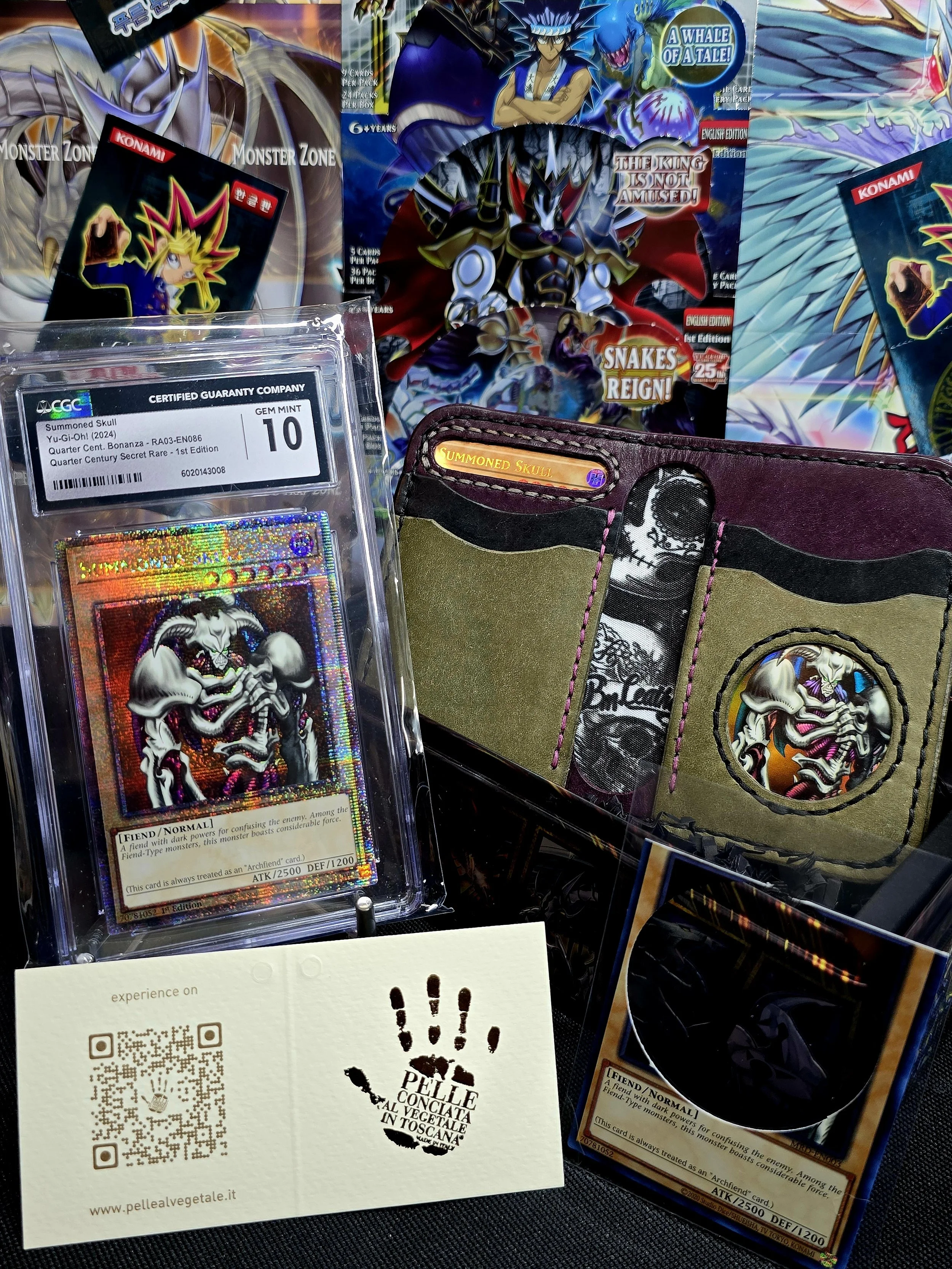 A collection of Yu-Gi-Oh! trading cards and related merchandise, including a holographic Summoned Skull card in a protective case, a multi-panel card holder, and several Yu-Gi-Oh! booster packs with colorful artwork and promotional labels.