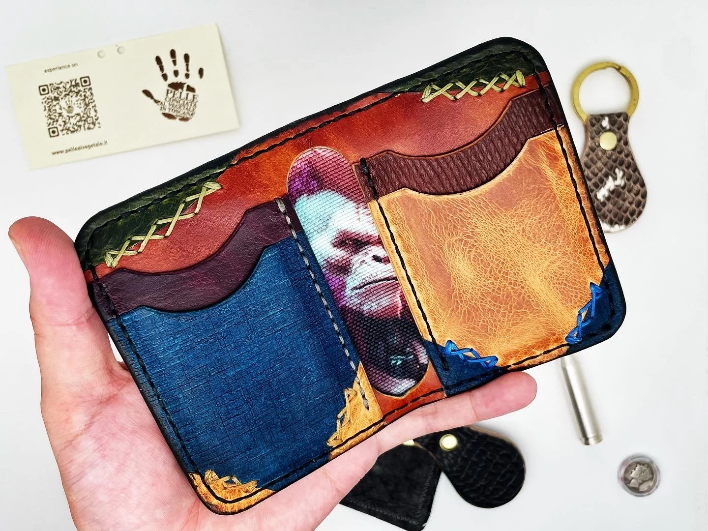 Colorful leather cardholder with a portrait of a smiling woman, featuring spade, heart, club, and diamond shapes on each section.