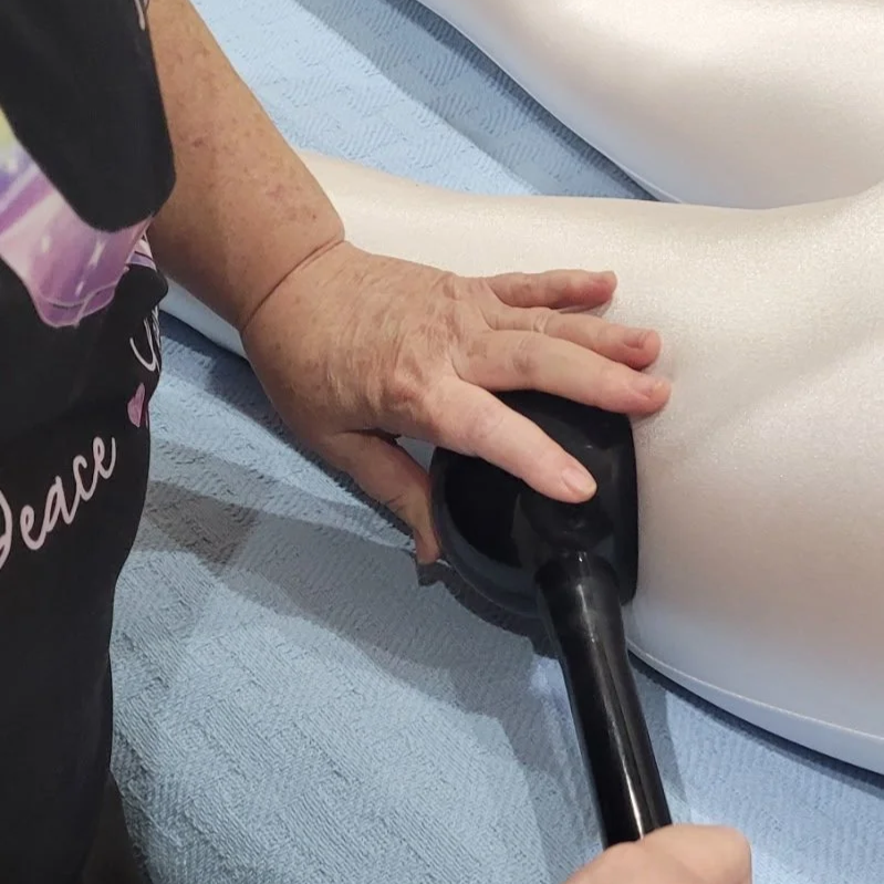 Client wearing a therapeutic compression suit during an Aesthetic Massage System (AMS) session at Joy's Special Touch in Lake Charles to aid lymphatic drainage and skin smoothing.