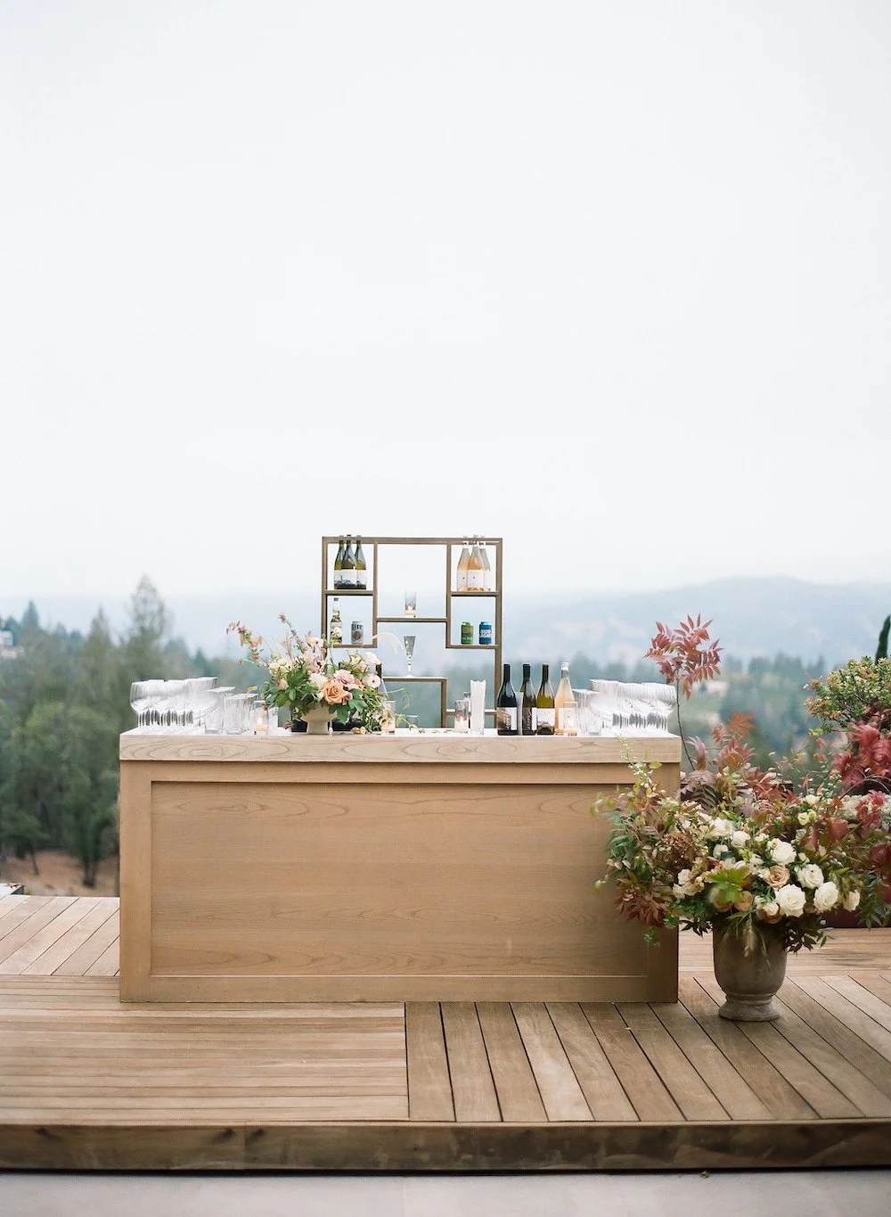 a wooden bar with florals and drinks on and around it for a wedding in napa