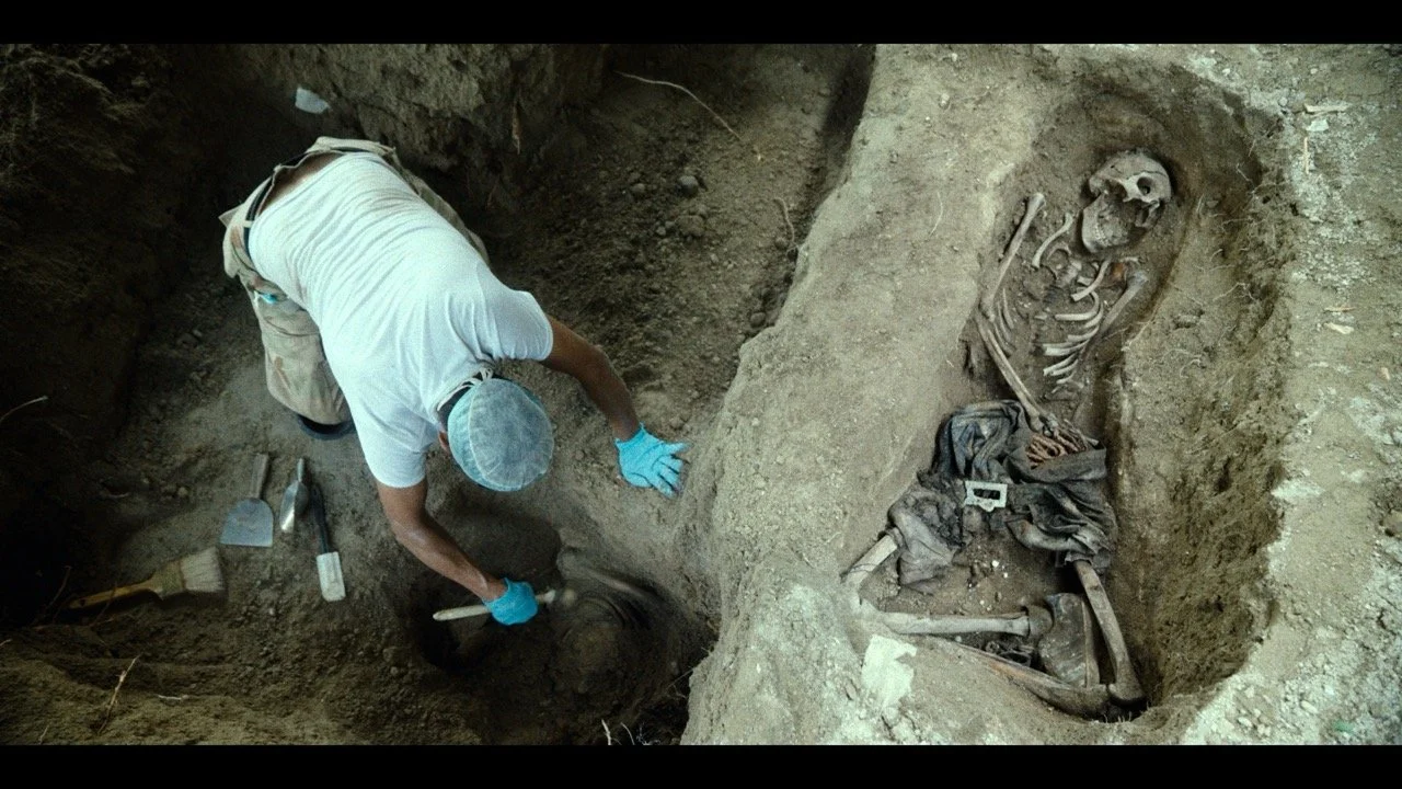 Archaeologist excavating an ancient human skeleton at an archaeological site.