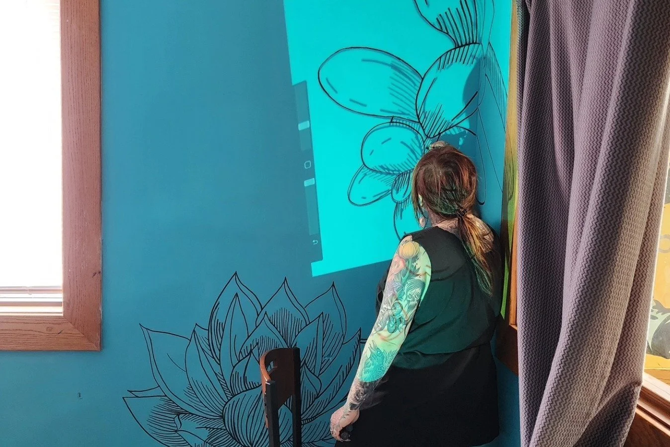 UnFair artist painting a mural at YMCA Safe Place in Louisville