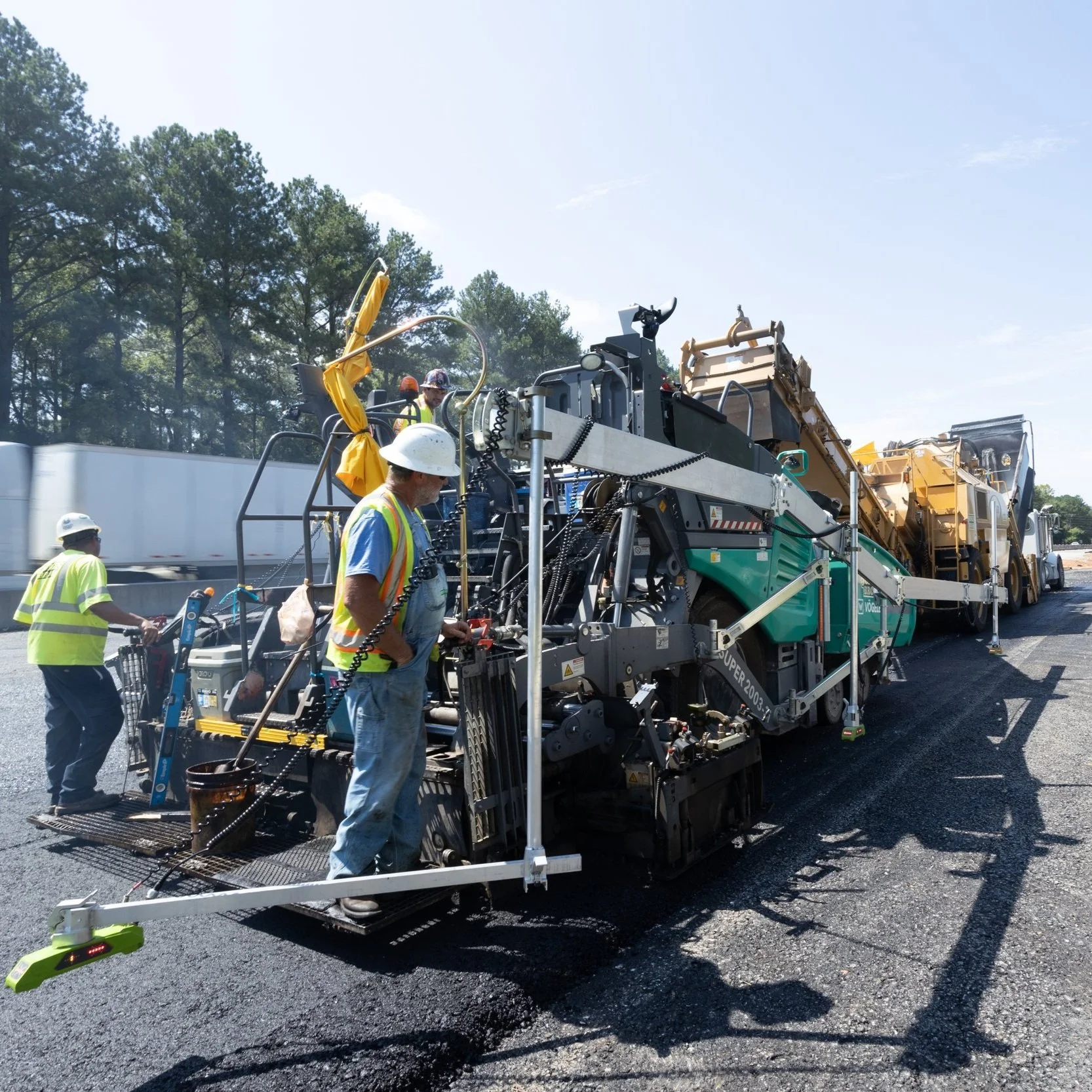 Men paving a major road.