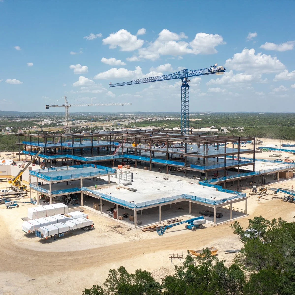 Drone shot of steel building under construction with a crane.