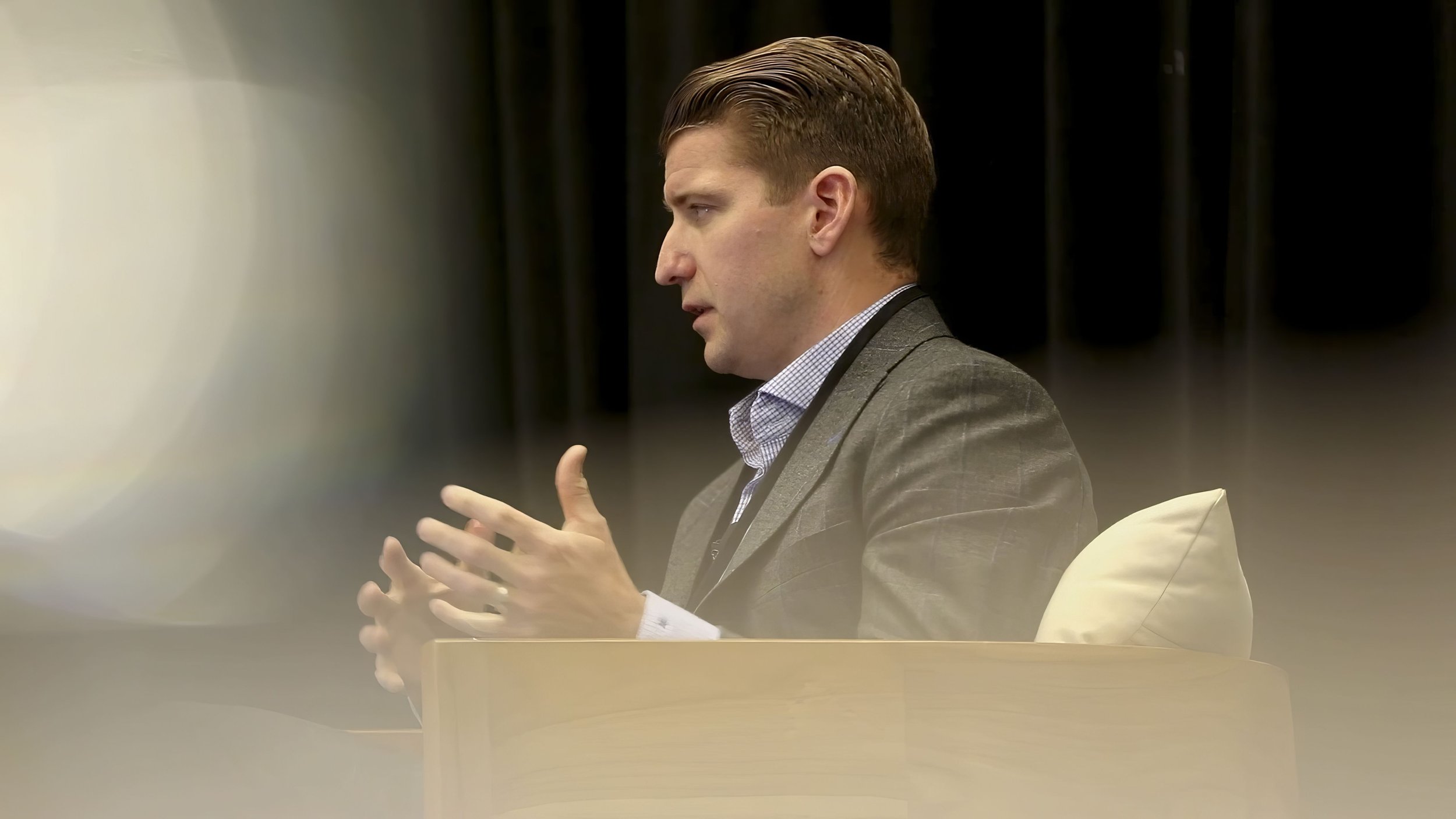 Man in a sport coat speaking on stage