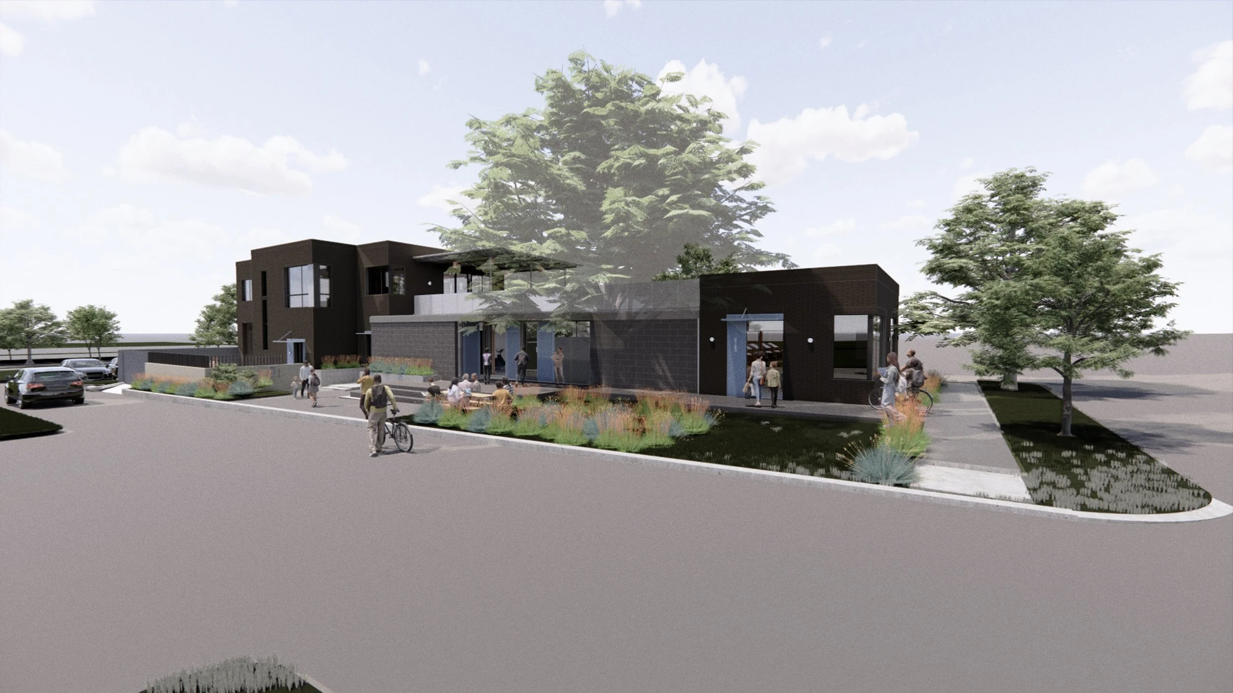 A modern community center with black exterior walls, large glass windows, and an outdoor seating area with people walking and cycling on a curved sidewalk, surrounded by landscaped plants and trees.