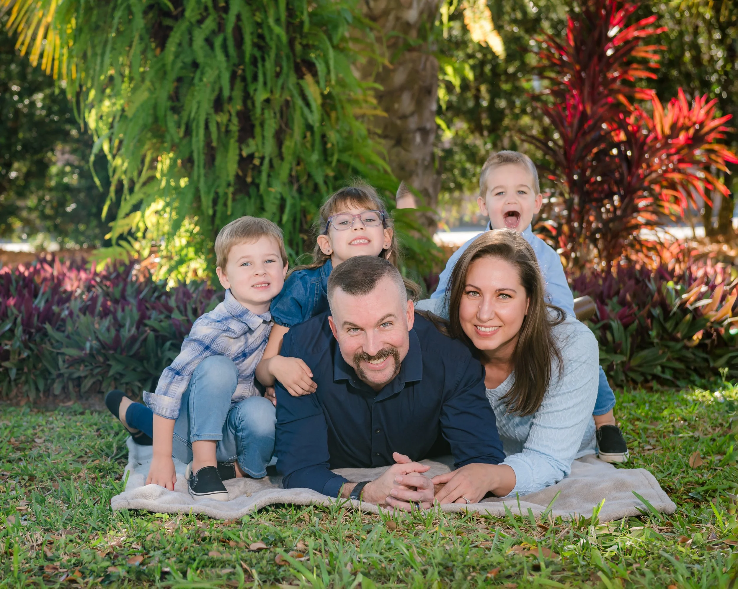 Children lying on parents laughing during a family portrait session in Downtown Cocoa, Florida