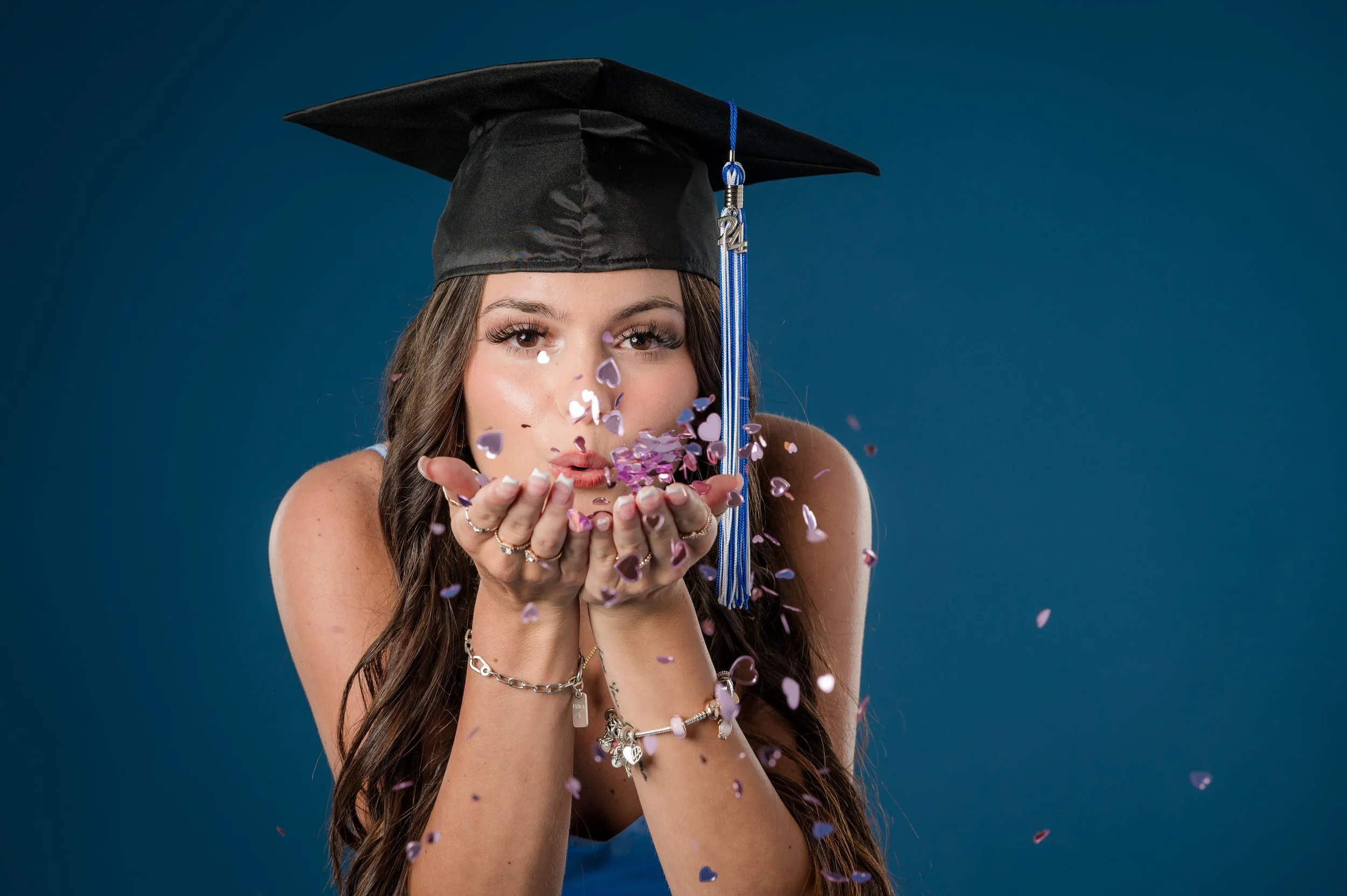 Female senior portrait blowing confetti in studio at Acevedo Photography Palm Bay, Florida