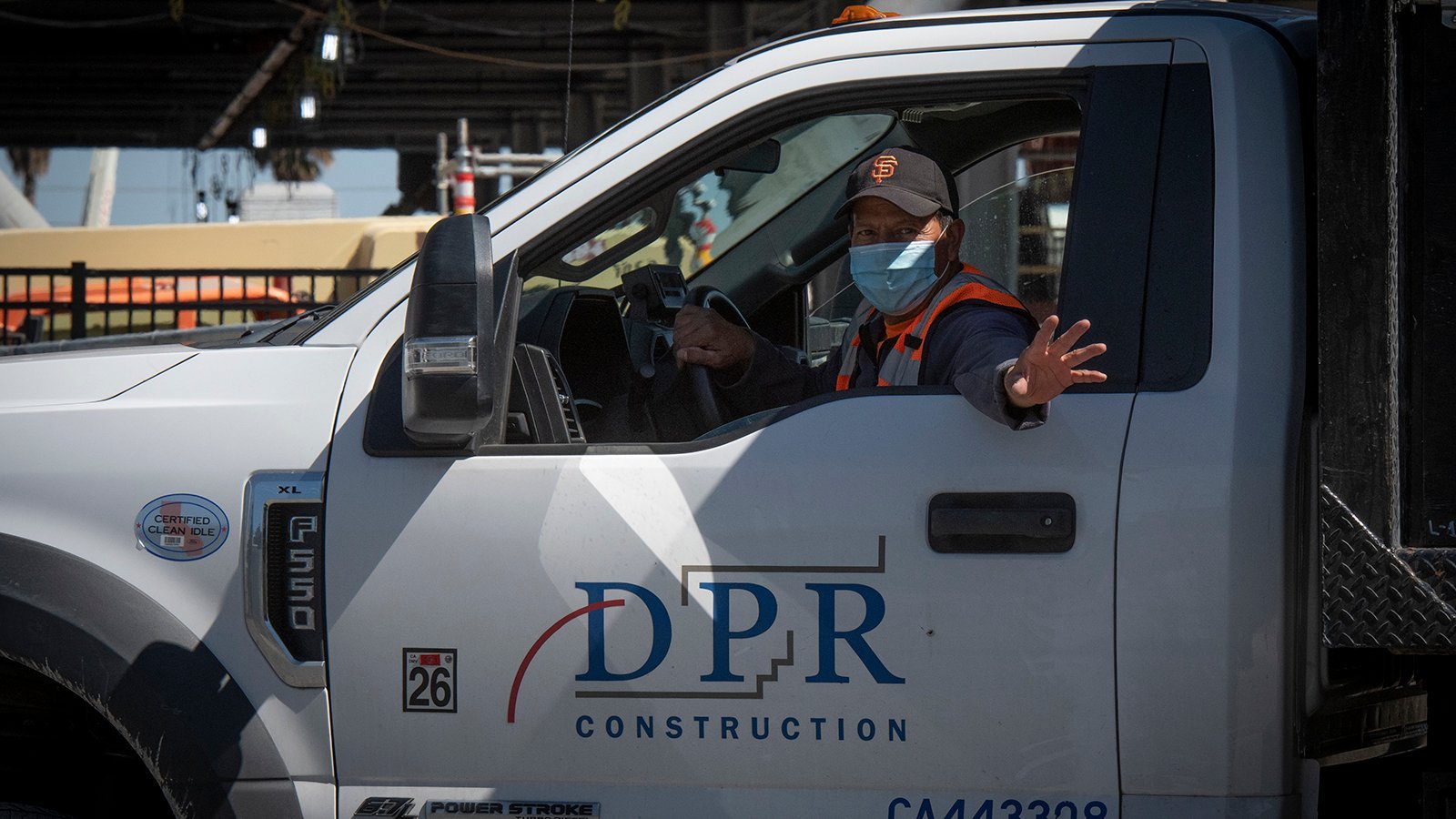 Branded DPR Construction F550 truck with a worker driving it and waving.